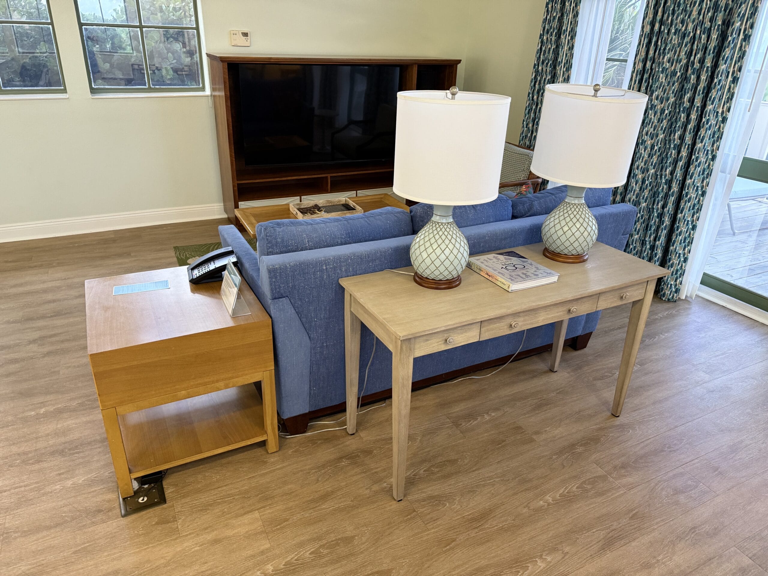 Cozy cottage with a blue sofa and lamps, styled like Disney’s Vero Beach Resort—not unlike the inviting lounges at Disney resorts.