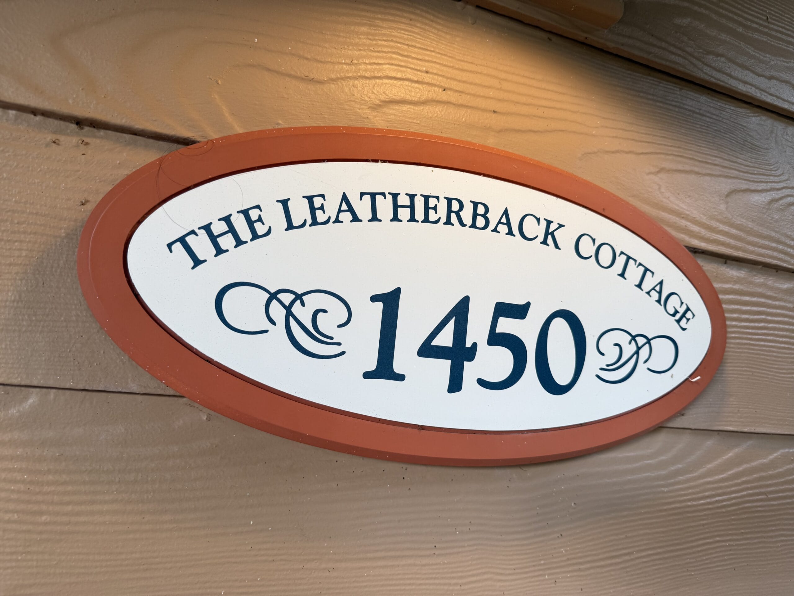 Oval sign with "THE LEATHERBACK COTTAGE 1450" on a wooden wall at Disney's Vero Beach Resort, no castle in sight here.