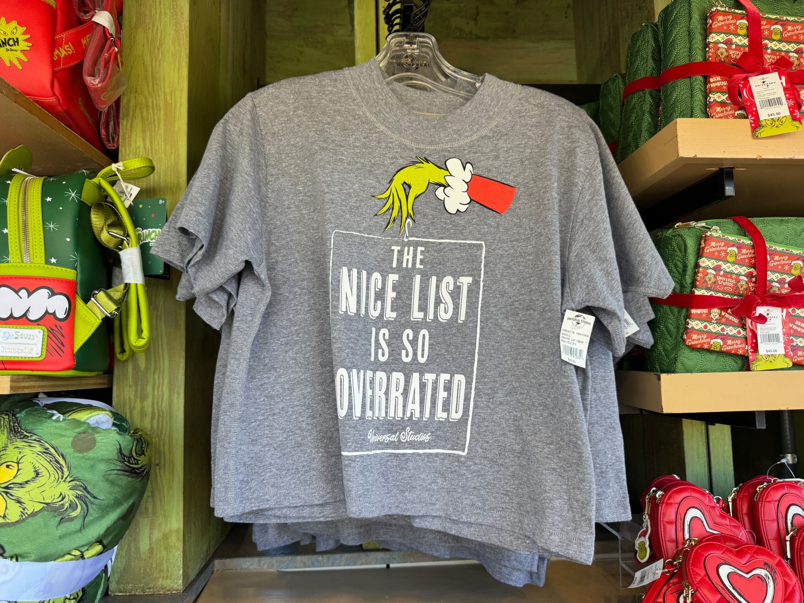 Gray Grinchmas T-shirt at Universal Orlando, Grinch’s hand with coal, “The Nice List Is So Overrated”—not a Disney castle.