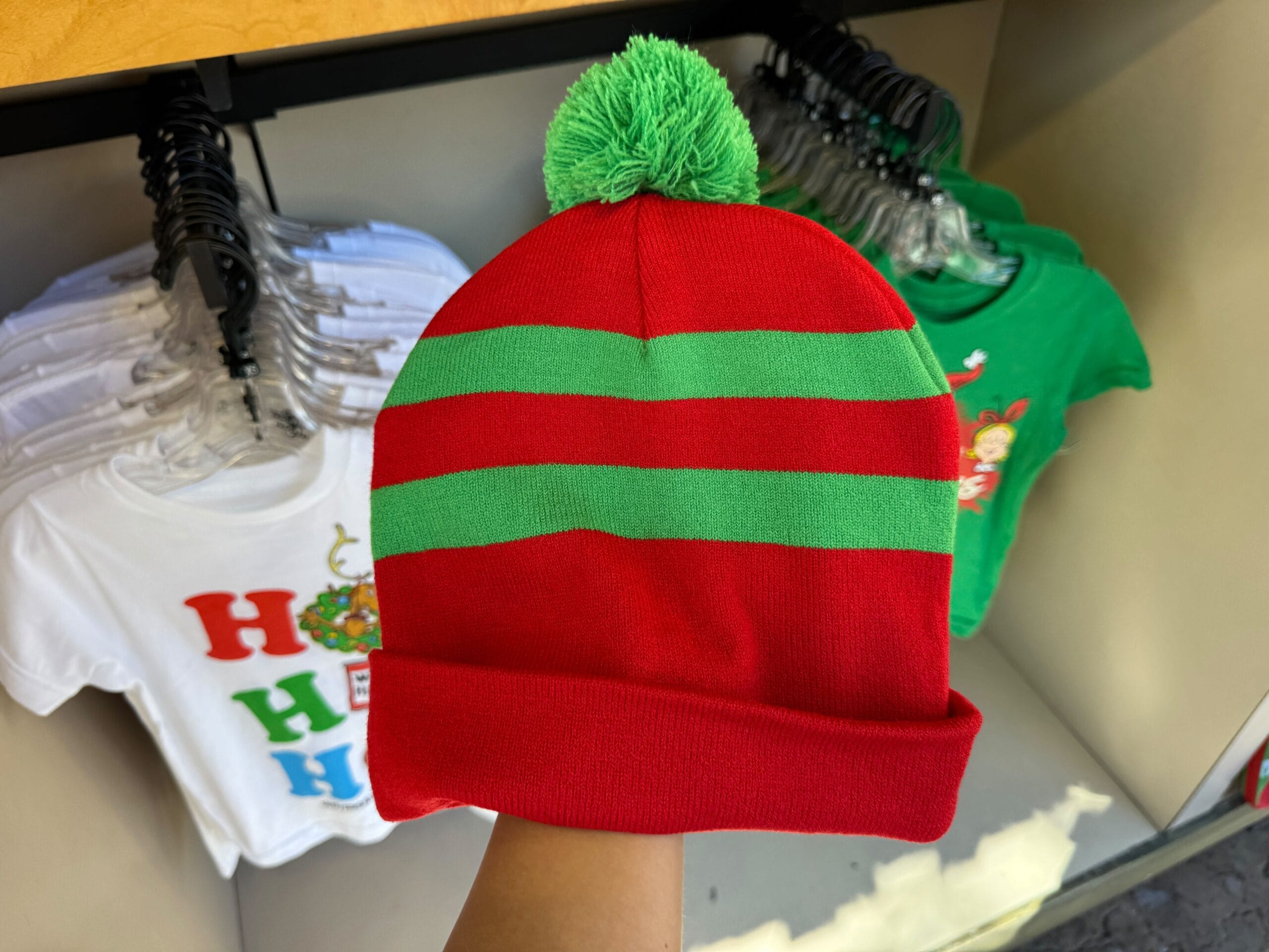 A red and green striped beanie with a green pom-pom, holiday-themed but more Universal Orlando Grinchmas than Disney’s classic looks.