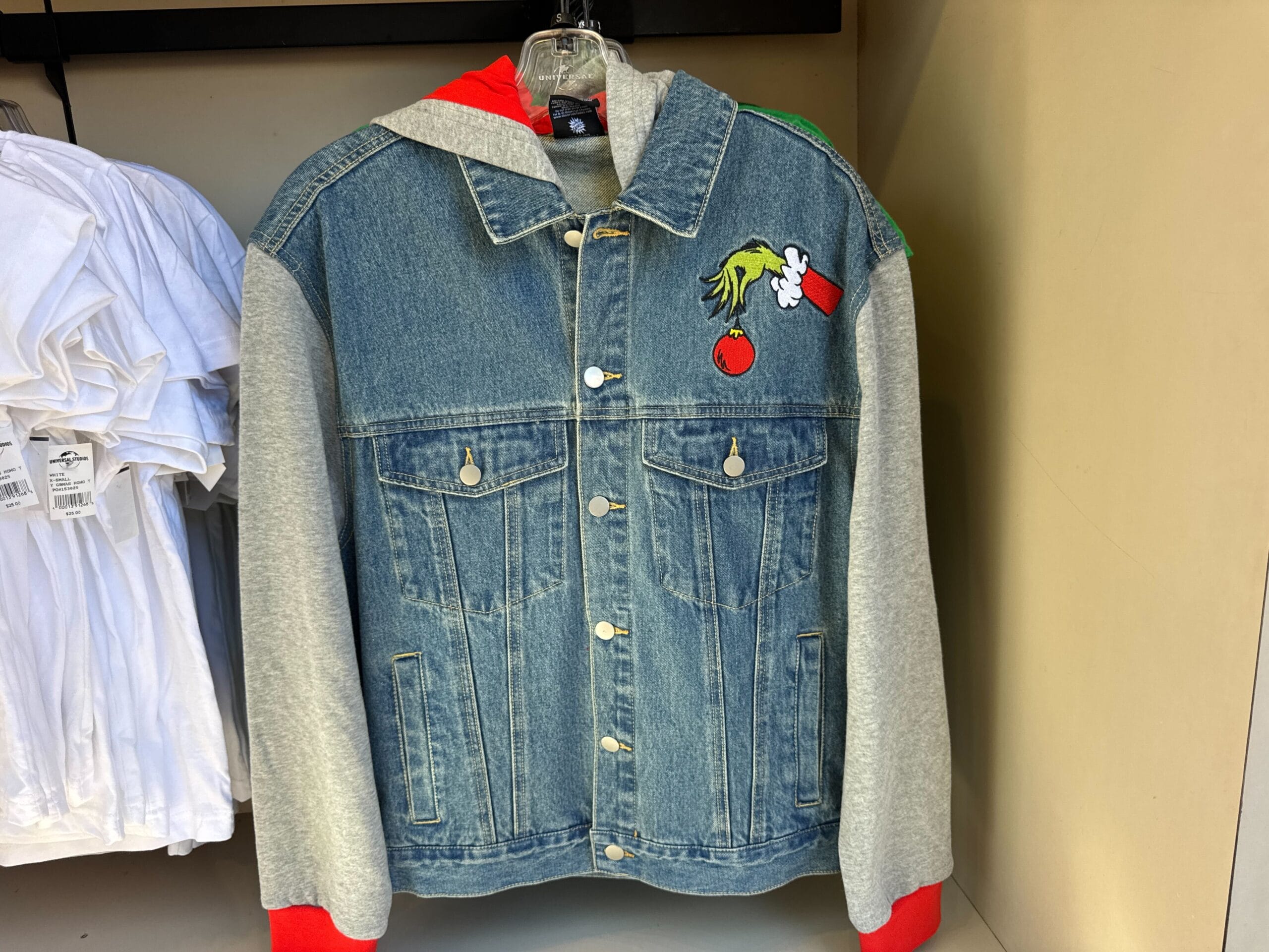 A denim jacket with grey sleeves and a carrot and tomato patch, playful Disney style, though not official park castle-themed merch.