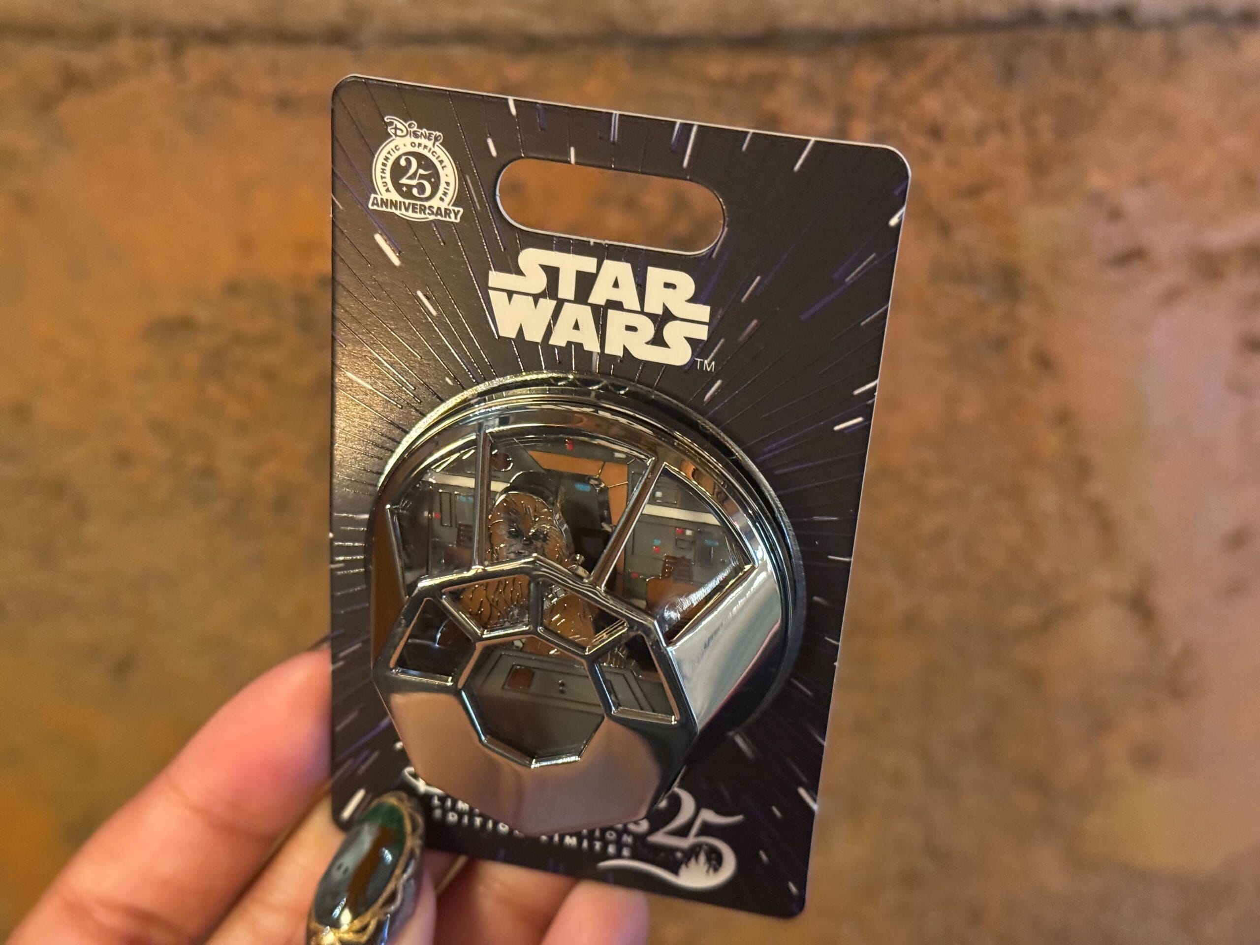 A three-dimensional pin depicts the Millennium Falcon cockpit with Chewbacca inside.