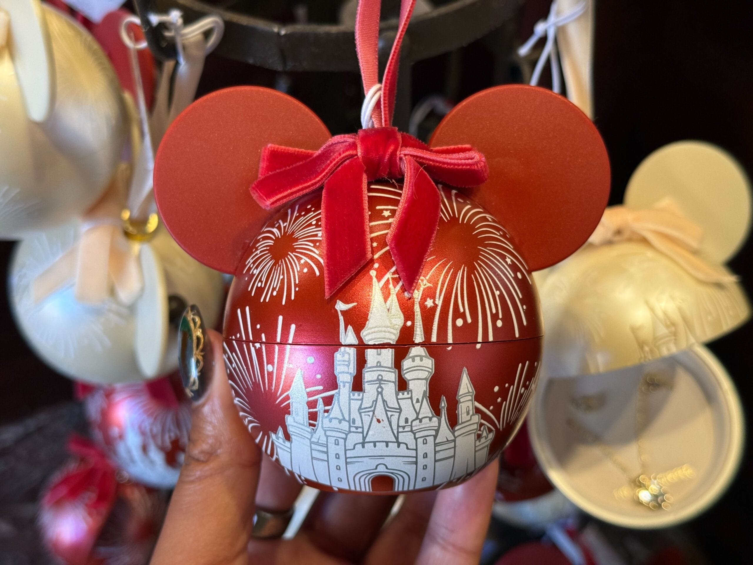 Red Mickey Mouse ornament with a white castle resembling Disneyland’s, fireworks above, from the 2025 Disneyland holiday collection.