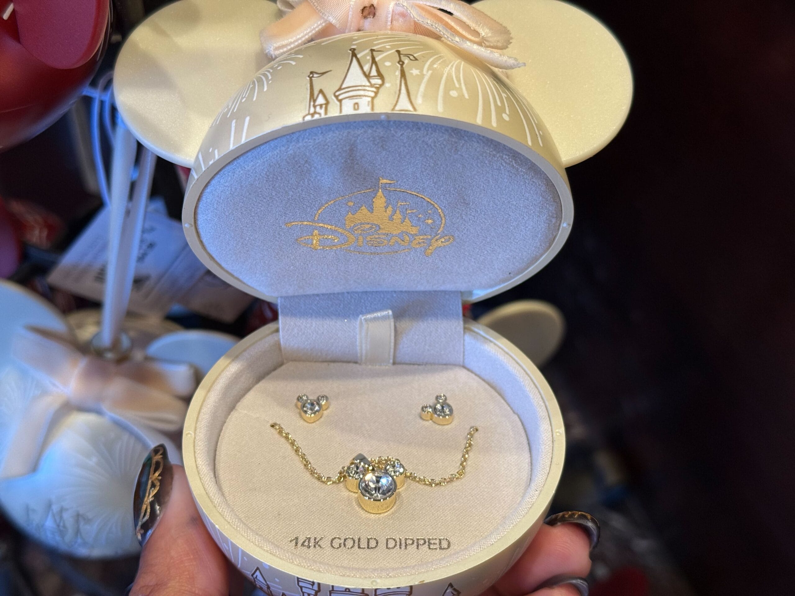 A 14k gold-dipped Disney jewelry set with earrings and a necklace, part of 2025 Disneyland holiday merchandise—no castle visible.