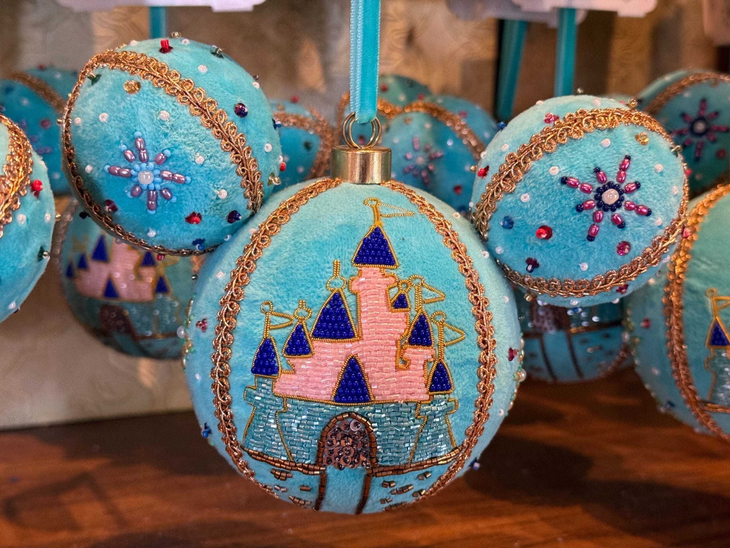 Blue Mickey Mouse-shaped ornament with beads, "2025," and a castle more similar to Disneyland's than Magic Kingdom's iconic centerpiece.