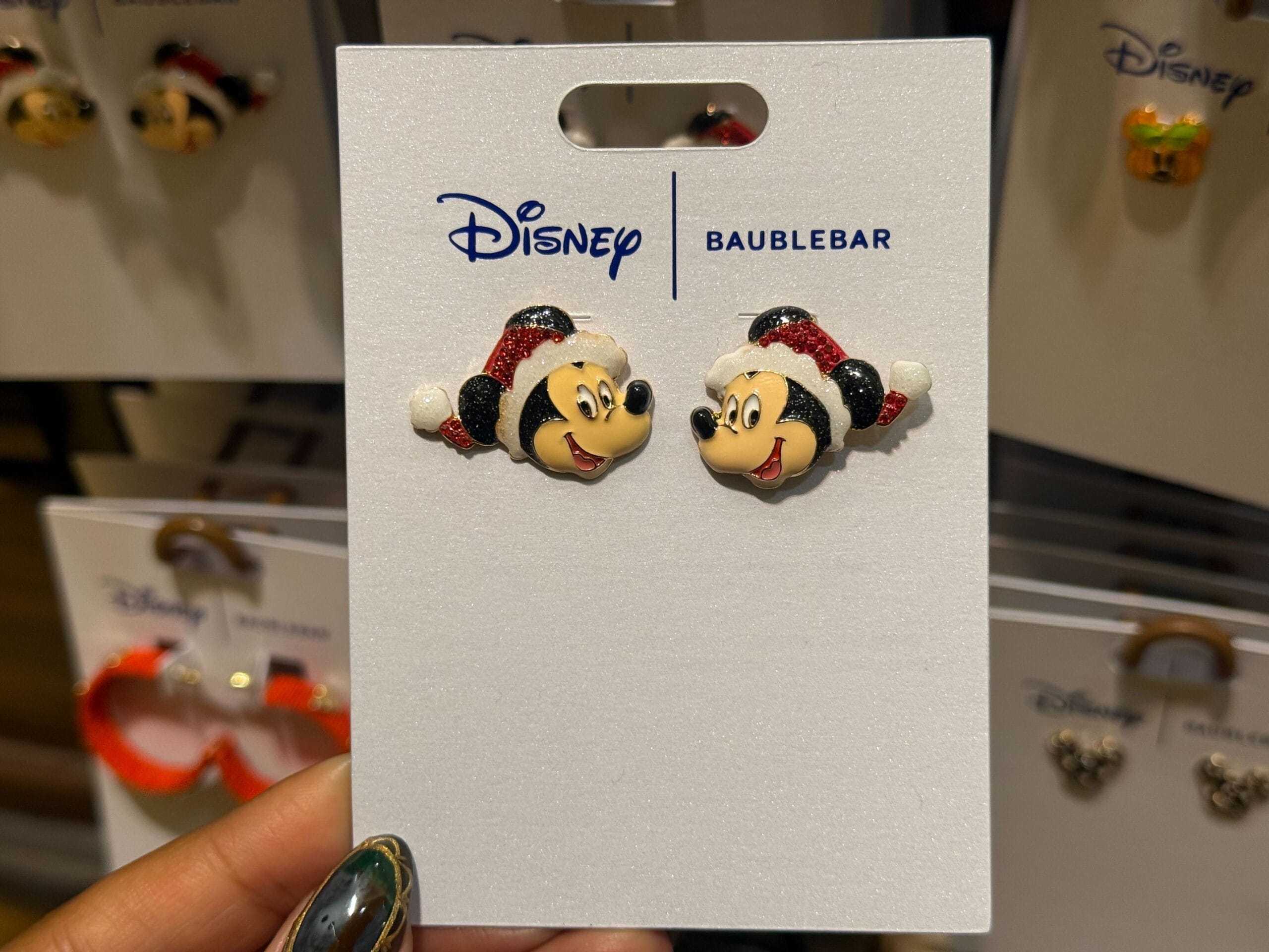 Disneyland holiday BaubleBar earrings: Mickey & Minnie in Santa hats, festive for 2025—no castle shown to compare globally.