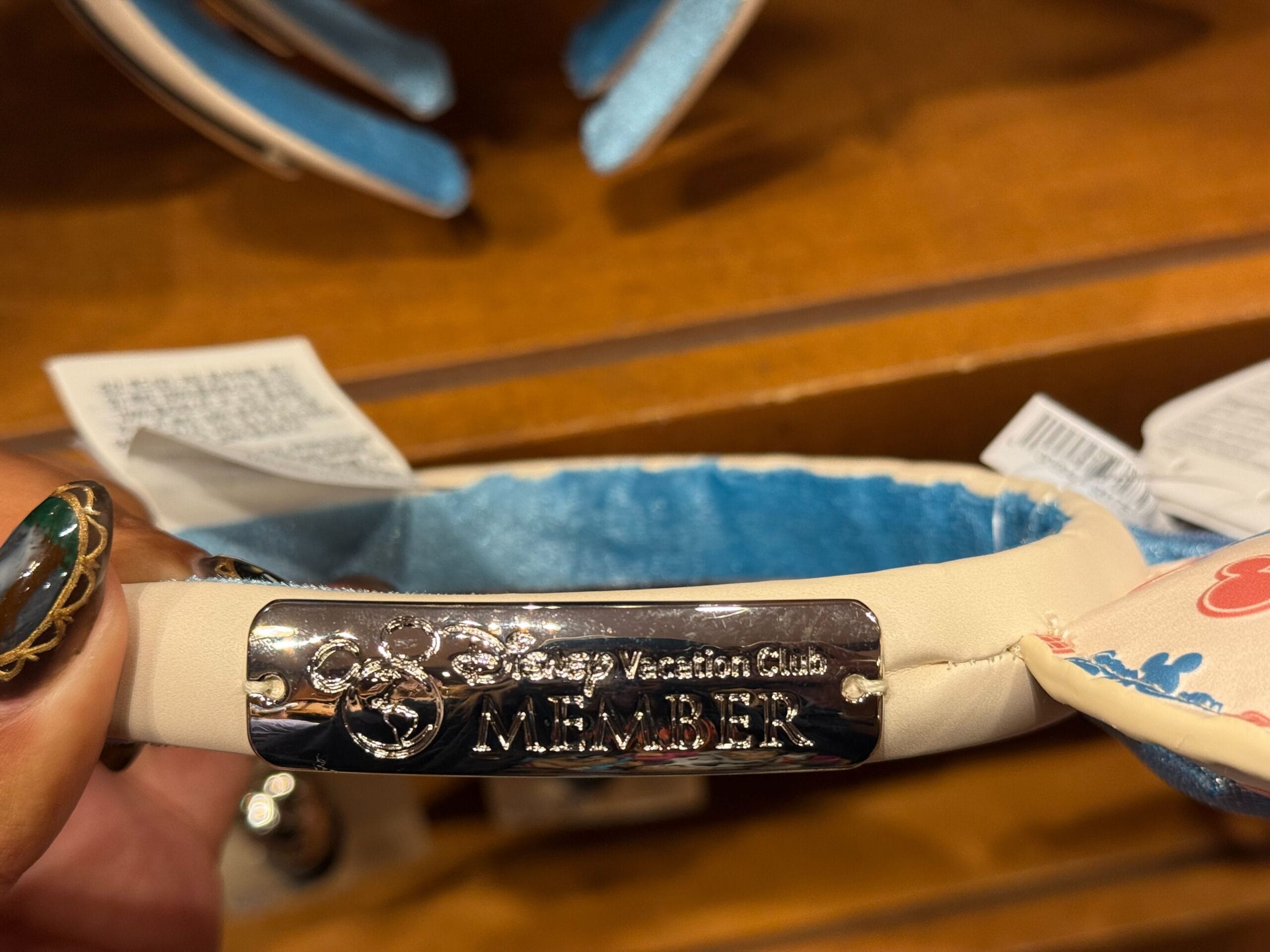 Close-up of a headband featuring a shiny "Disney Vacation Club MEMBER" plate, spotted at one of the Disney Parks—classic DVC merch!