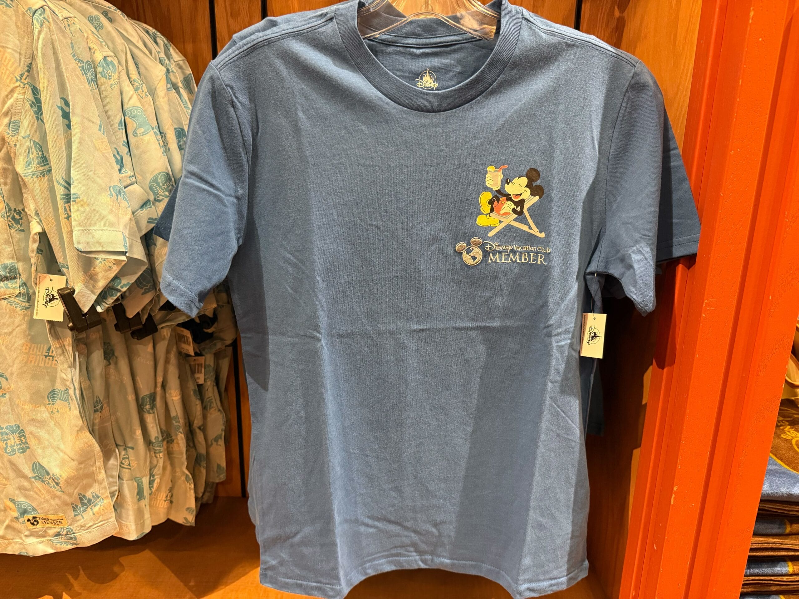 A blue t-shirt featuring cartoon Mickey characters, perfect merch for any Disneyland goer—pairs well with any Disney castle visit.