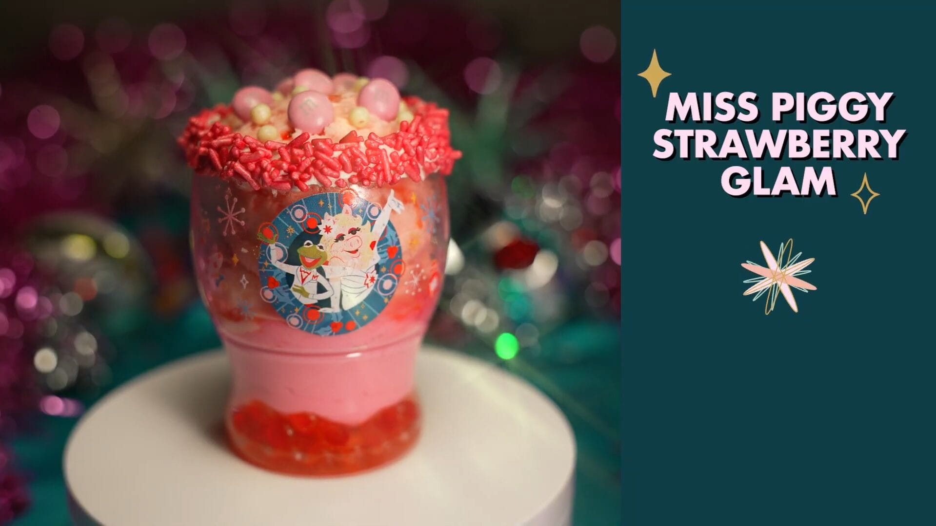 A pink strawberry drink topped with candies and sprinkles, featured as a glamorous treat at Disney Jollywood Nights in the parks.