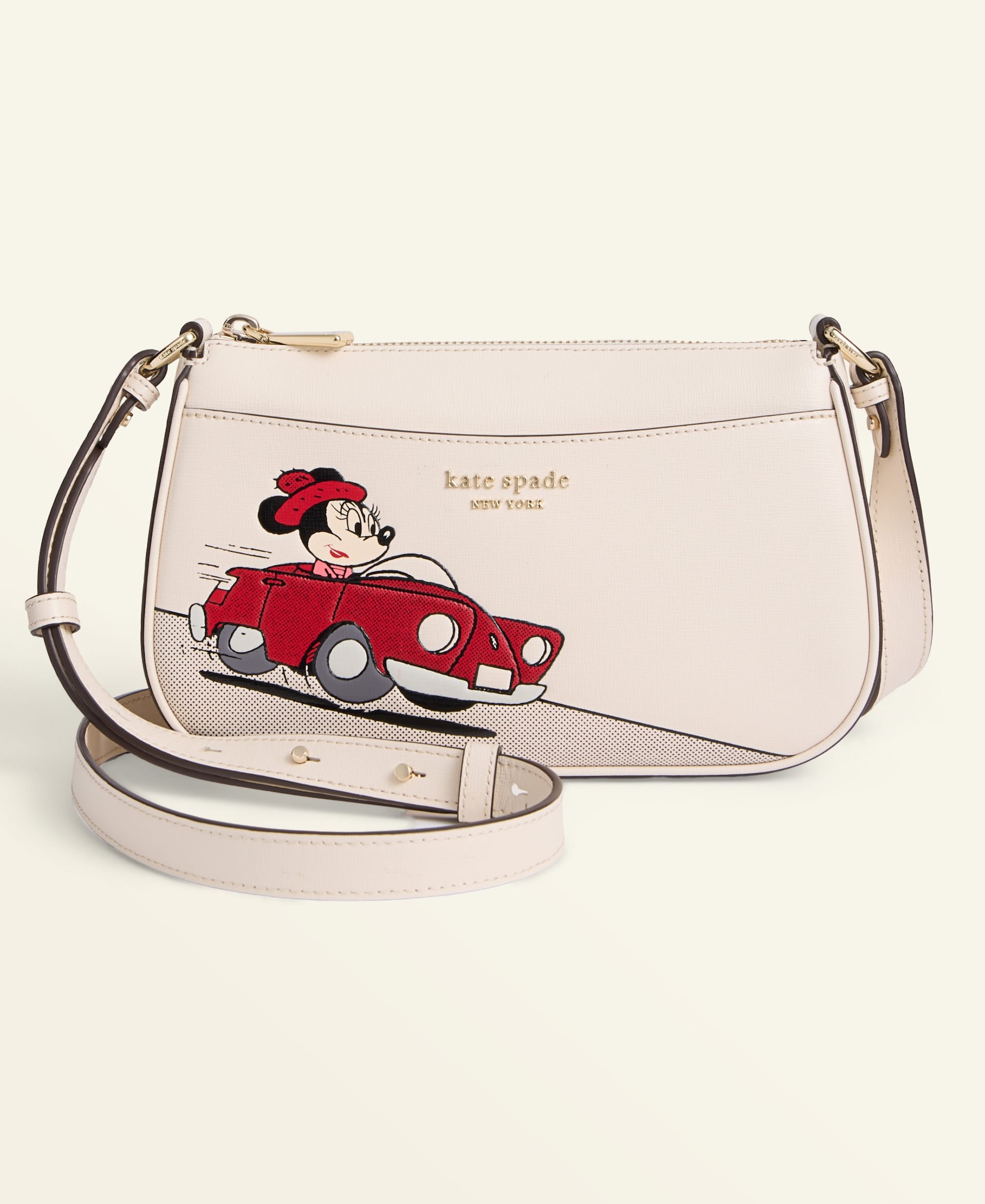 Cream Kate Spade crossbody bag featuring Minnie Mouse driving a red car, 2025 Holiday Collection, perfect for Disney park visits.