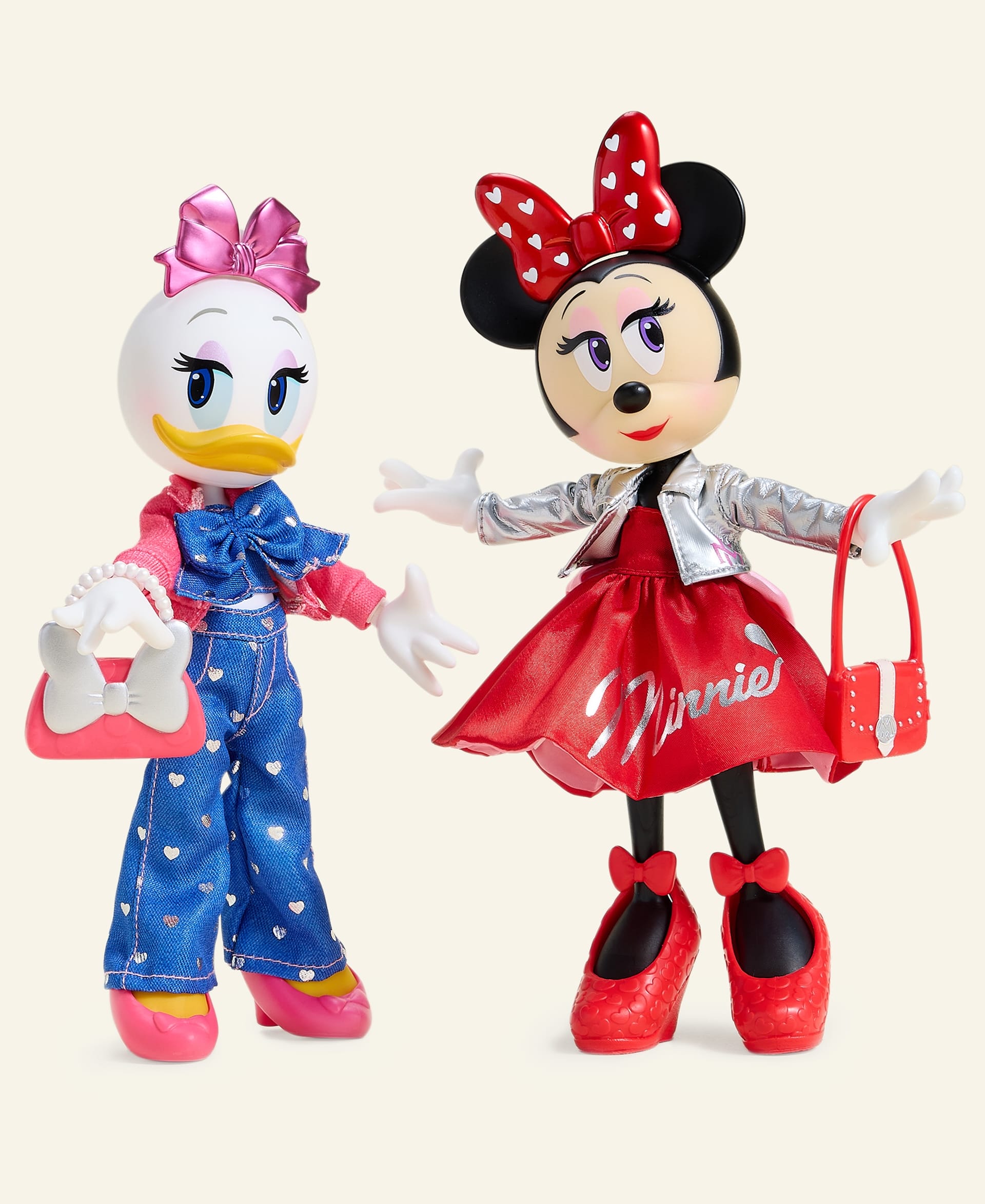 Daisy Duck and Minnie Mouse dolls from the 2025 Holiday Collection, with chic purses and big bows, like Disney park icons.