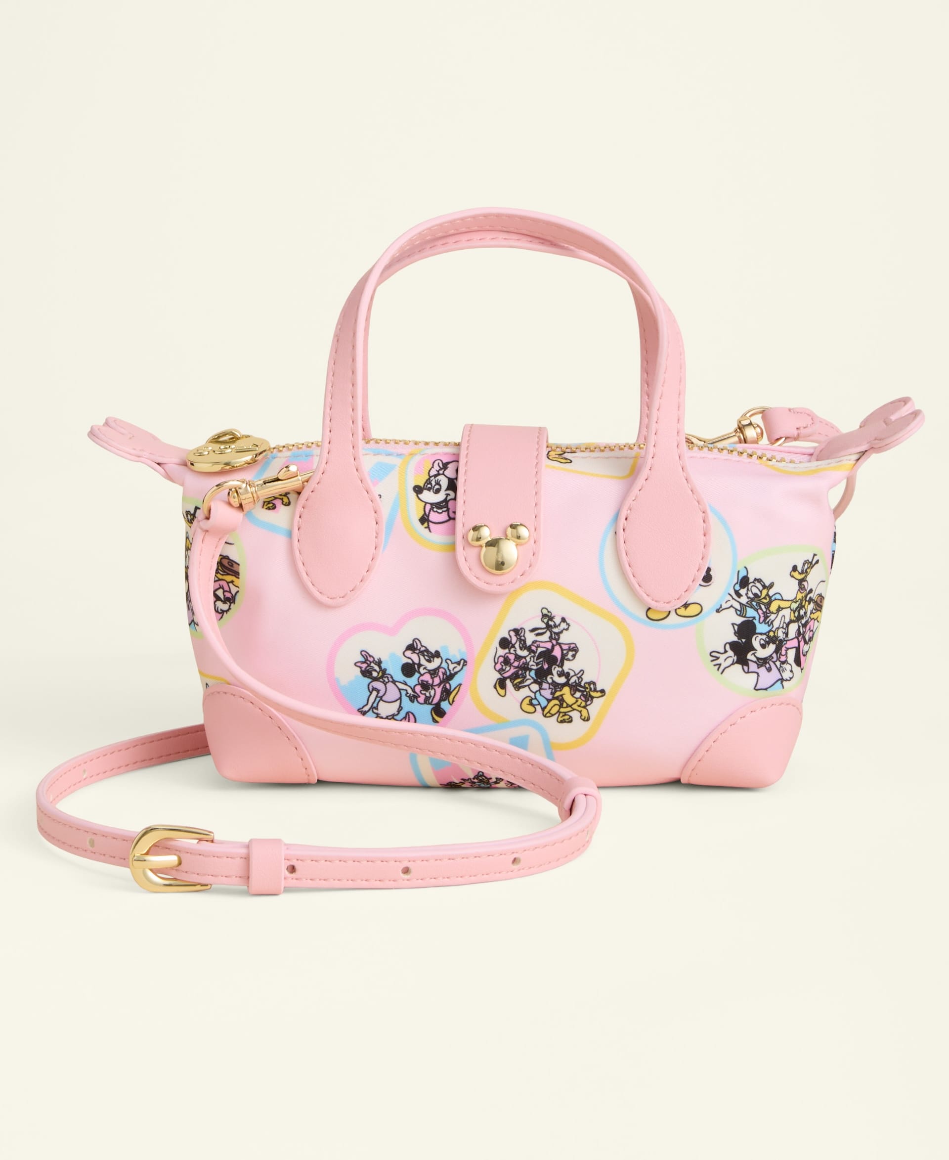Pink handbag featuring Disney cartoon prints, gold hardware, and detachable strap, reminiscent of stylish park merchandise.