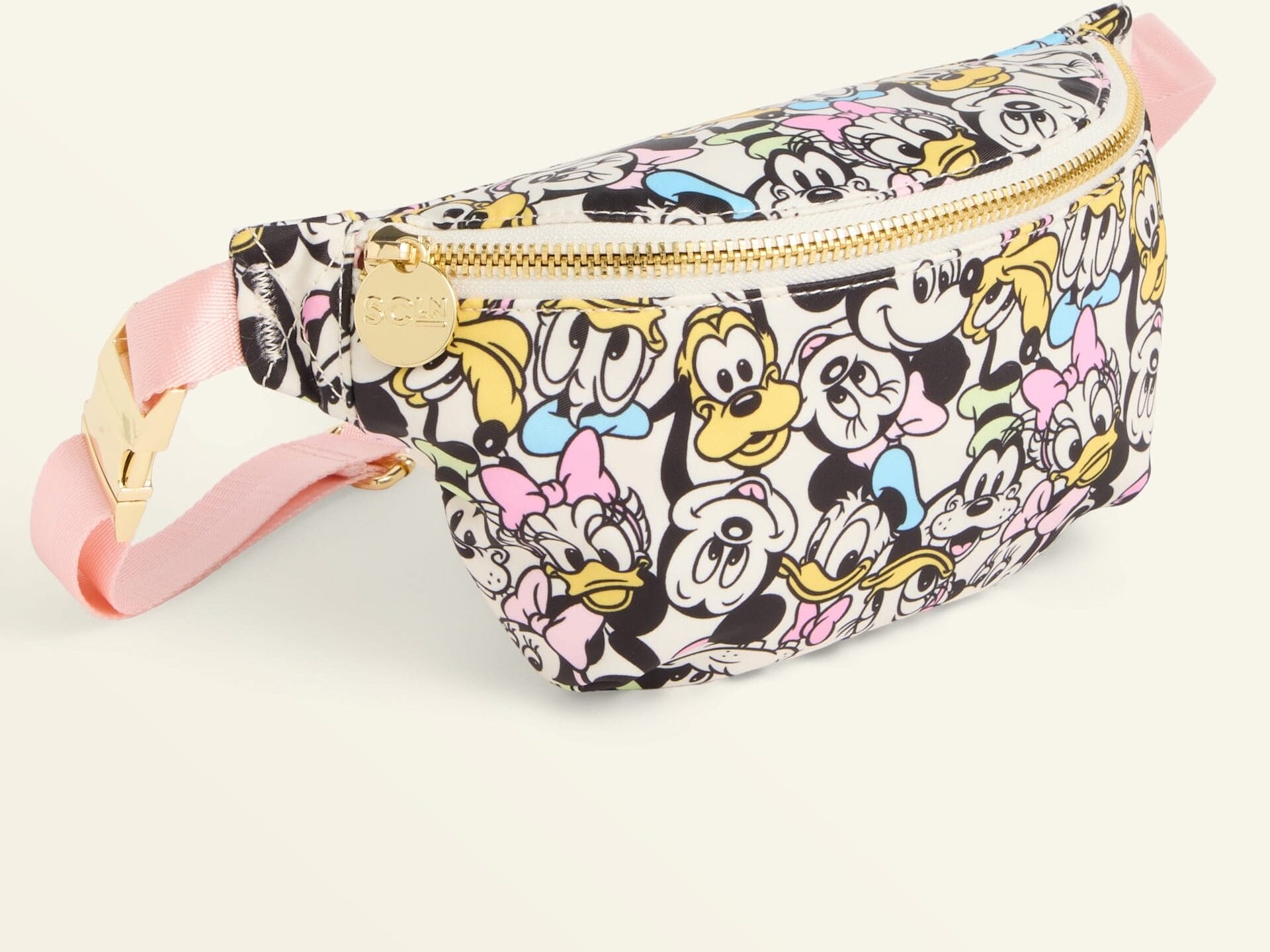 A Disney Holiday Collection fanny pack at Macy's, adorned with character faces, a pink strap, and gold touches—Disney Parks style.