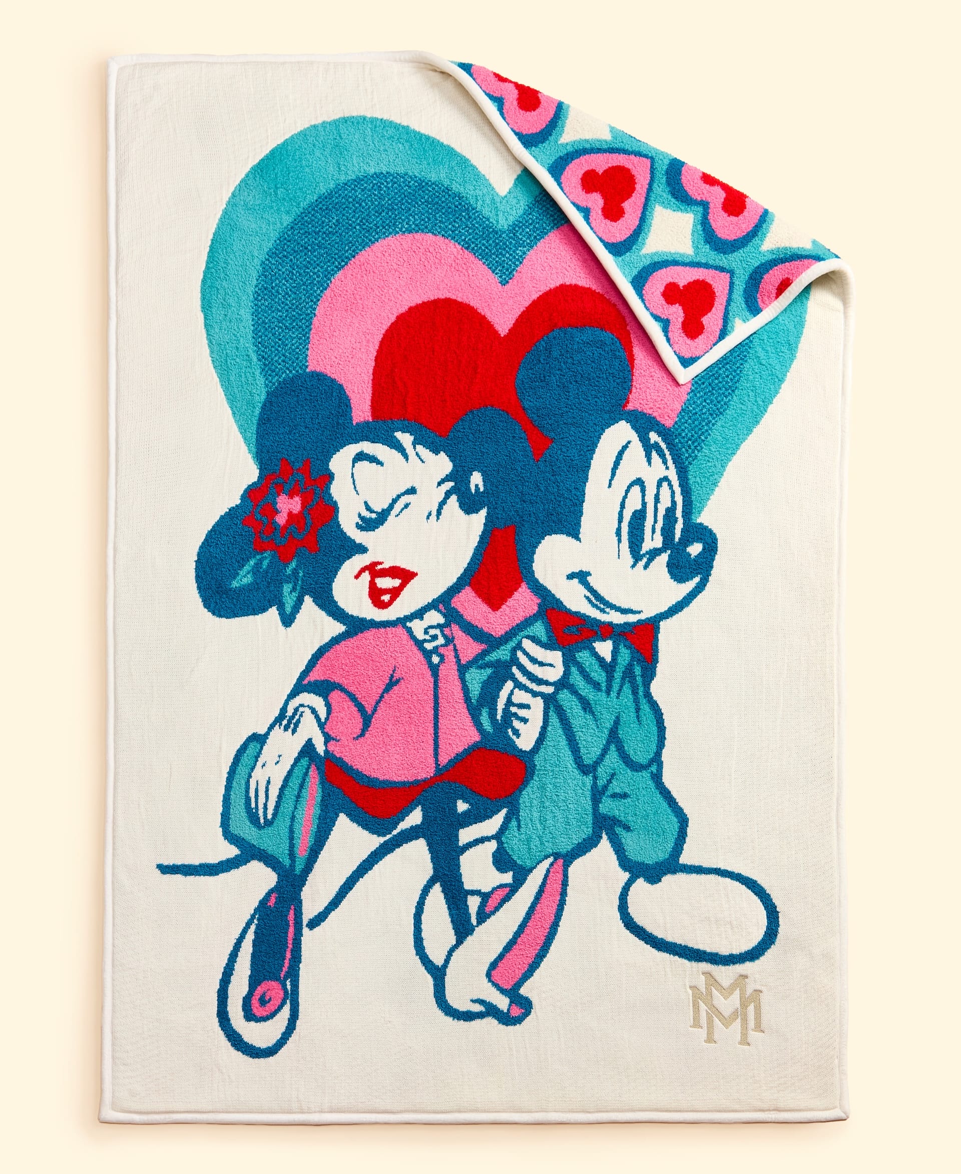 A Disney Holiday Collection blanket from Macy's with Minnie & Mickey holding hands, colorful hearts, and a heart-patterned back.