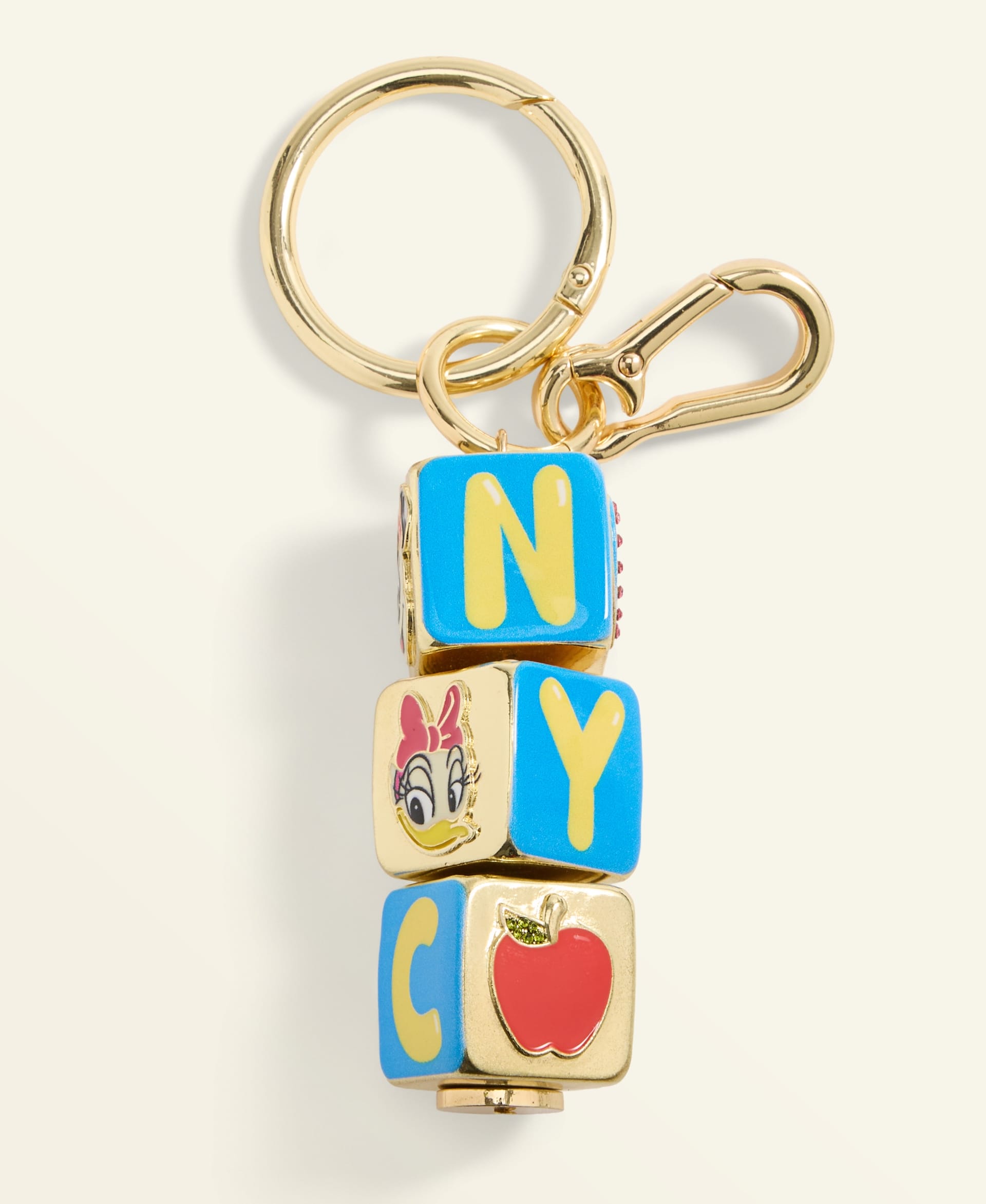 Gold keychain with four NYC letter blocks and red apple charm, similar in style to souvenirs at the Main Street Emporium in Disney Parks.