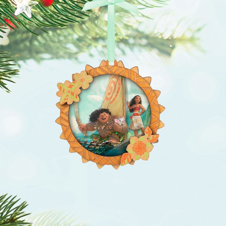 Hallmark Disney Keepsake Ornament with Moana, Maui, and Pua sailing, hanging by green ribbon, reminiscent of park merch.