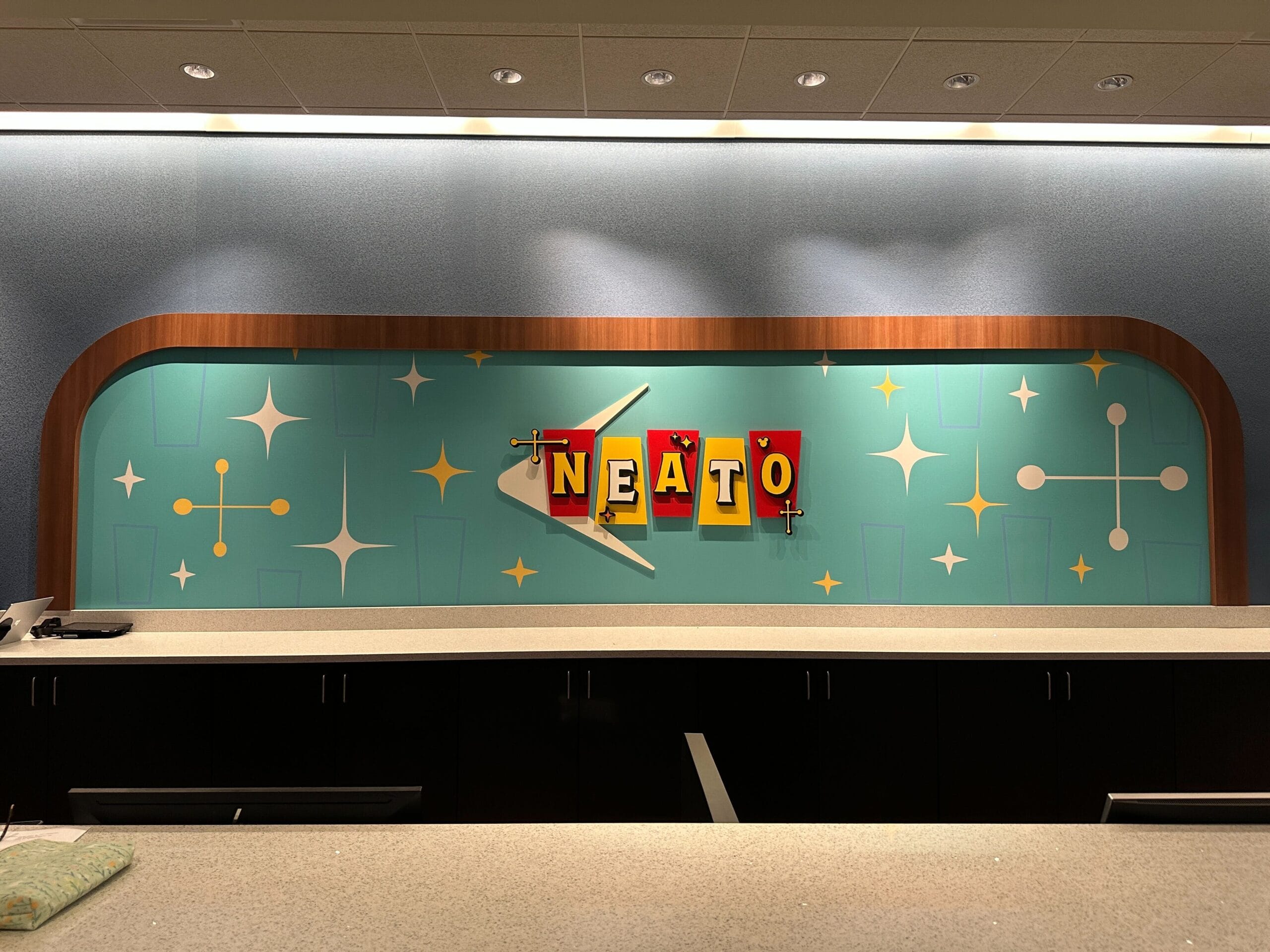 A retro-themed wall at Disney's Pop Century Resort says "NEATO" in red and yellow lettering surrounded by starbursts.