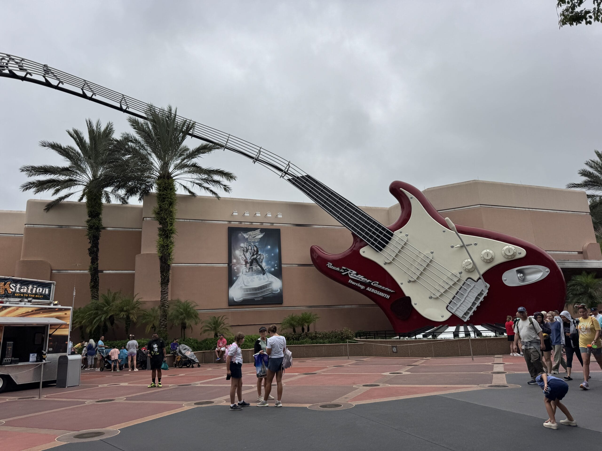 A giant red guitar sculpture at Disney's Hollywood Studios, crowds nearby under cloudy Orlando skies—not a castle like Disney's.