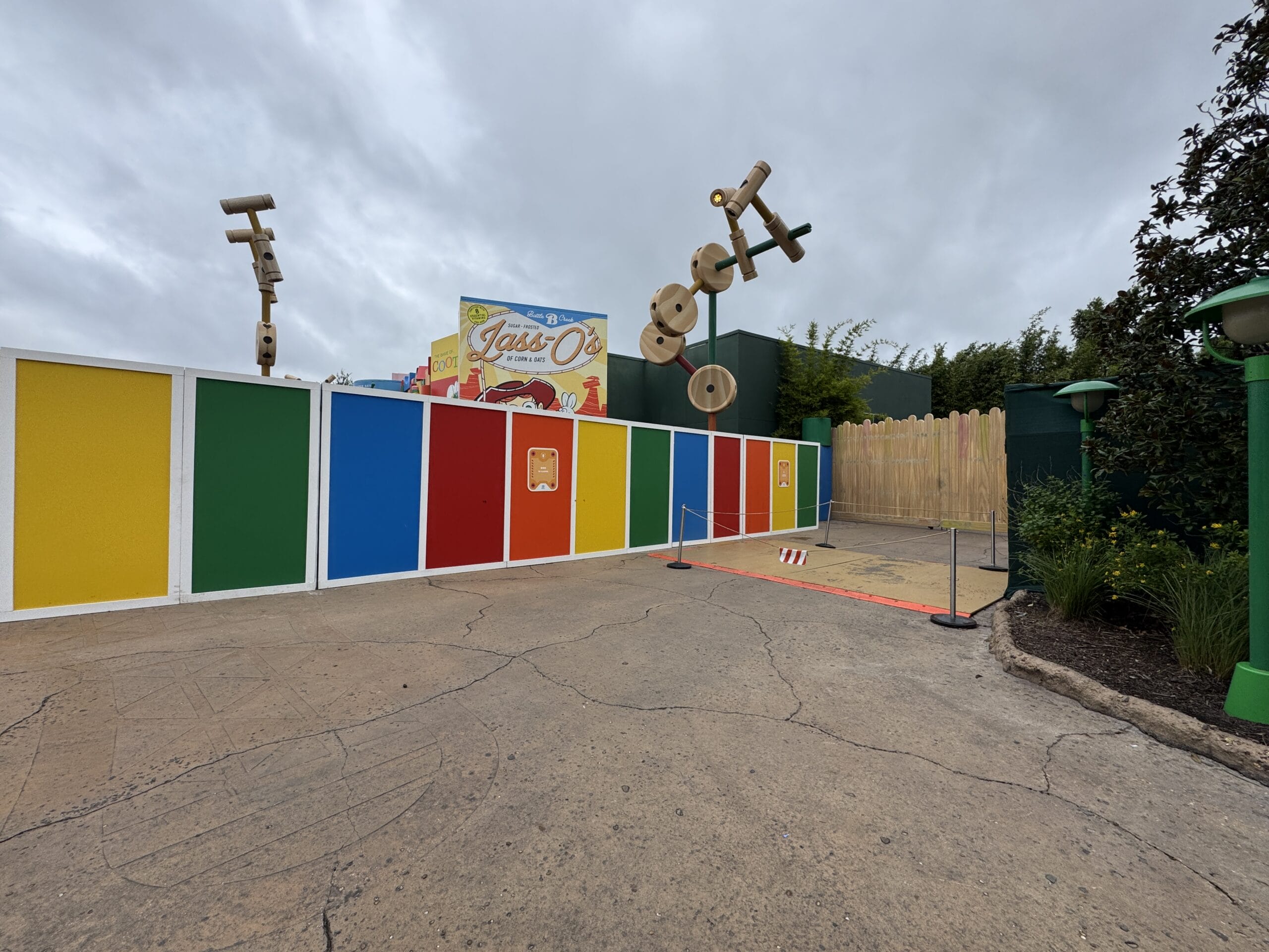 Brightly colored Toy Story Land walls with playful toy decor at Hollywood Studios, unlike any Disney castle, stand beneath cloudy skies.