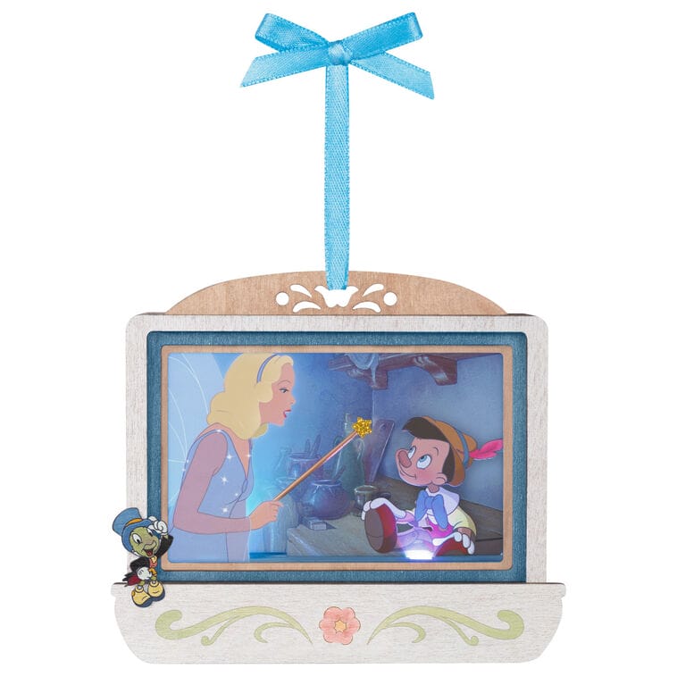 Disney Parks ornament featuring Pinocchio, Blue Fairy, and Jiminy Cricket displayed on a screen, dangling from a blue ribbon.