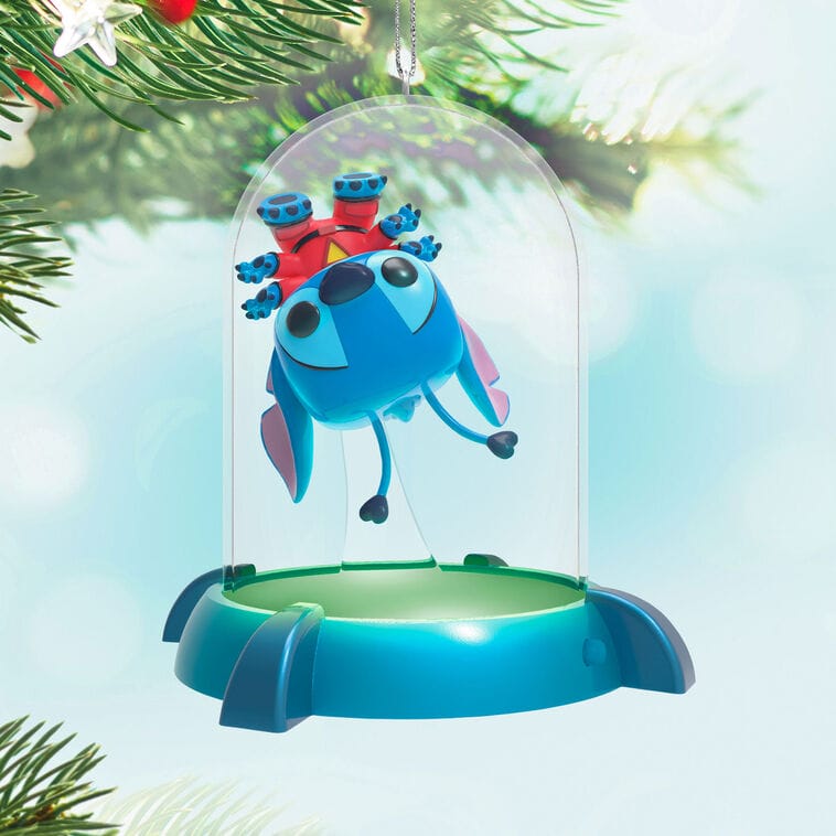 Disney Keepsake Ornament: Upside-down Stitch in a glass dome hangs on a tree, reminiscent of park decor near Cinderella Castle spires.