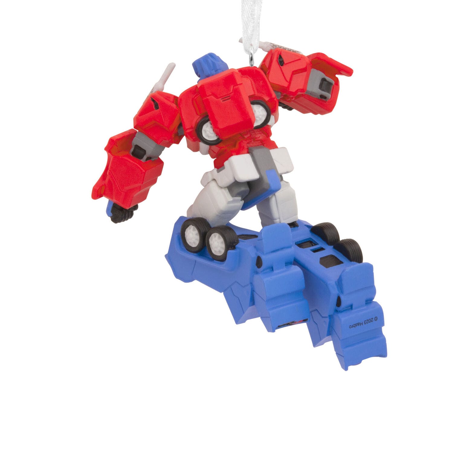 Red and blue robot ornament hangs by a white ribbon on blue vehicle parts