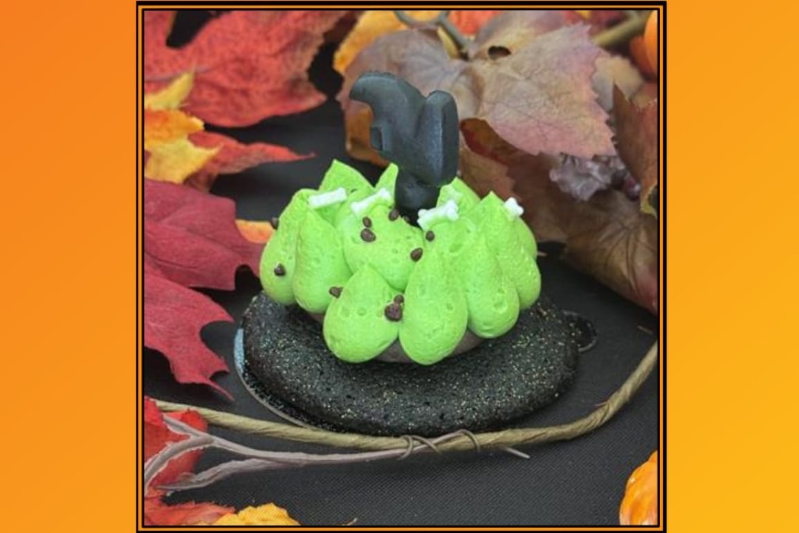 Spooky green monster dessert with chocolate chips, a number 4, and autumn leaves—no Cinderella Castle like at Disney parks.