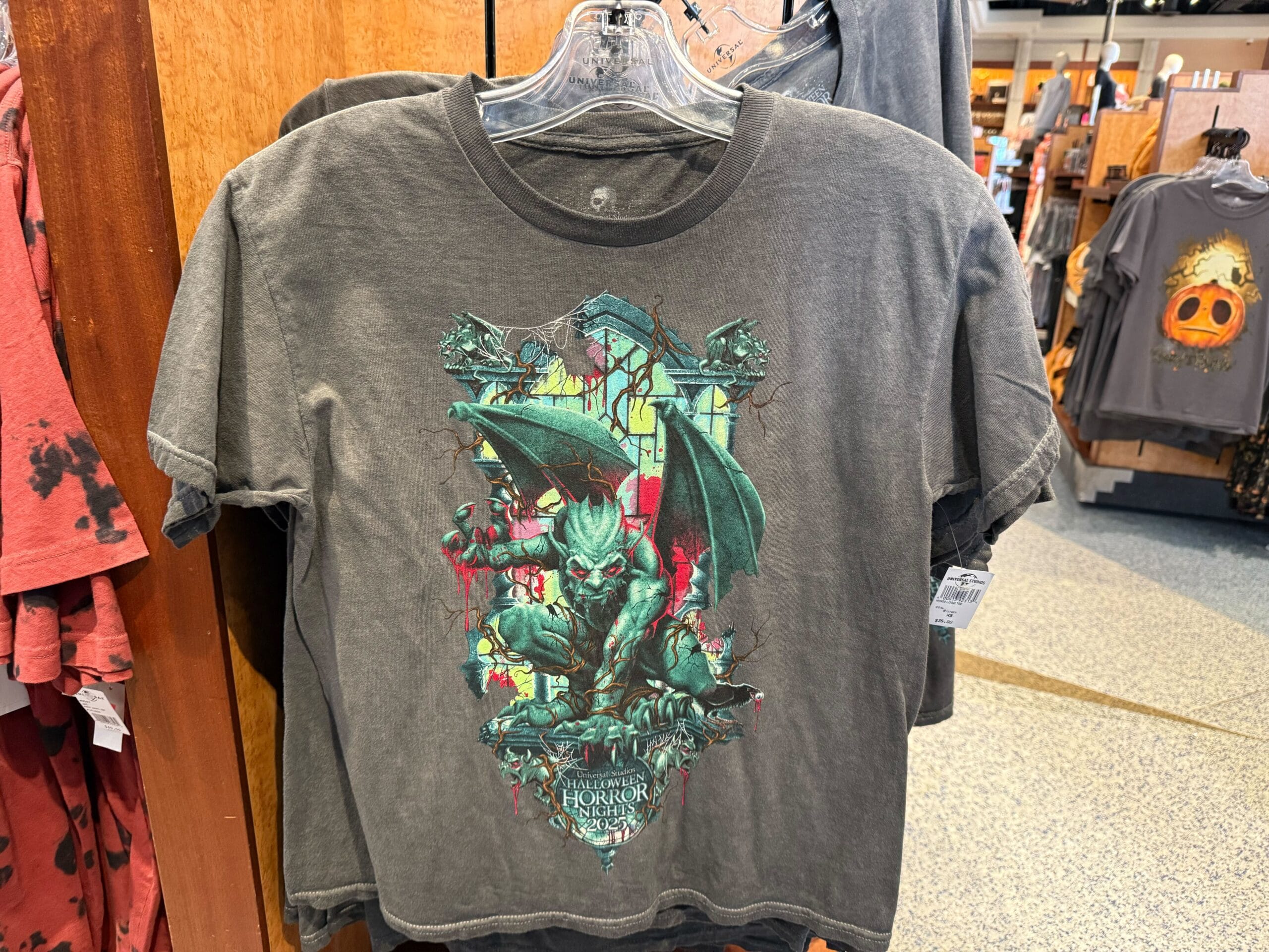 Gray t-shirt features a fierce gargoyle in front of a stained glass window with "Universal Studios Halloween Horror Nights" text.