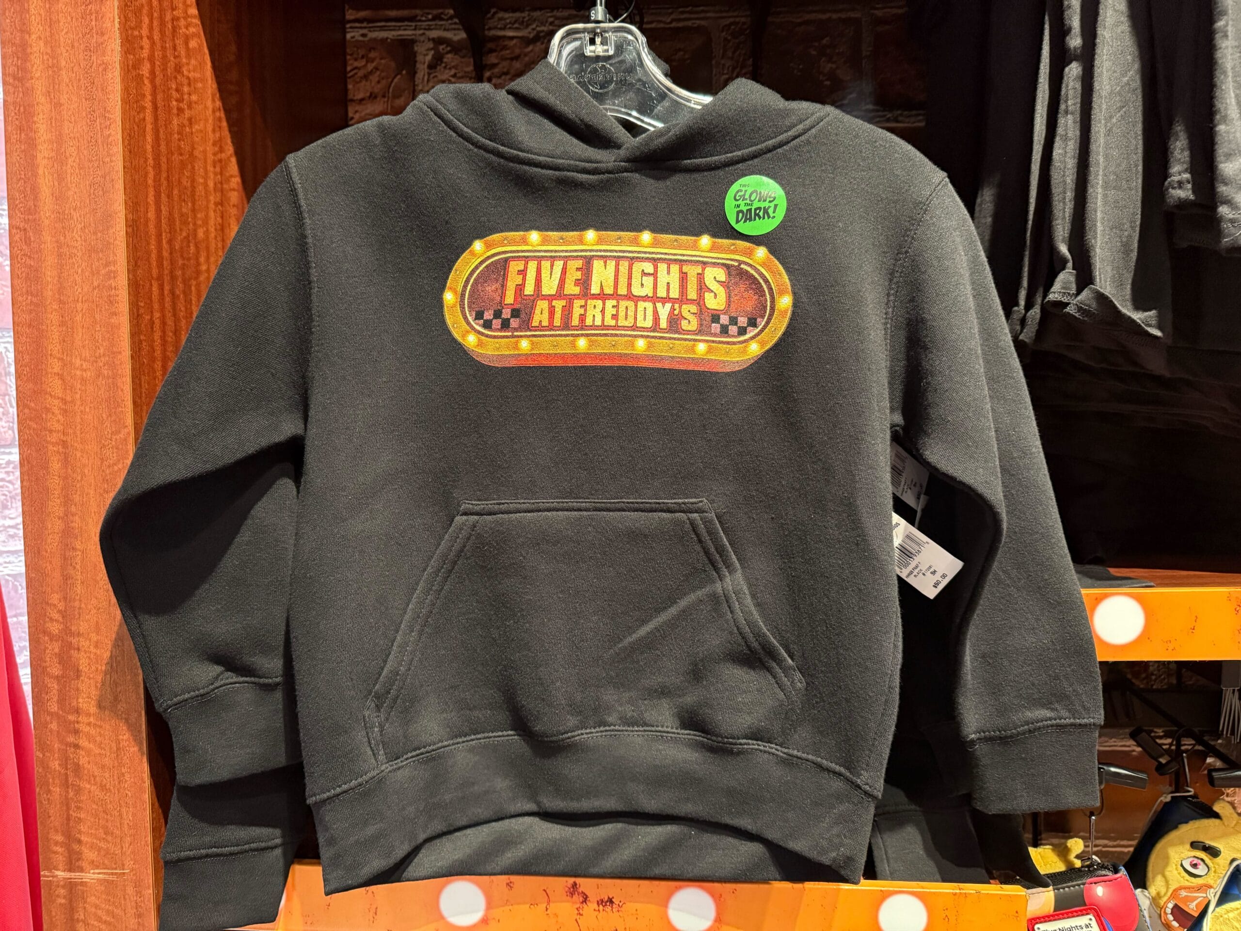A black hoodie with a "Five Nights at Freddy's" logo, showcased as 2025 Halloween Horror Nights merchandise at Universal Studios.