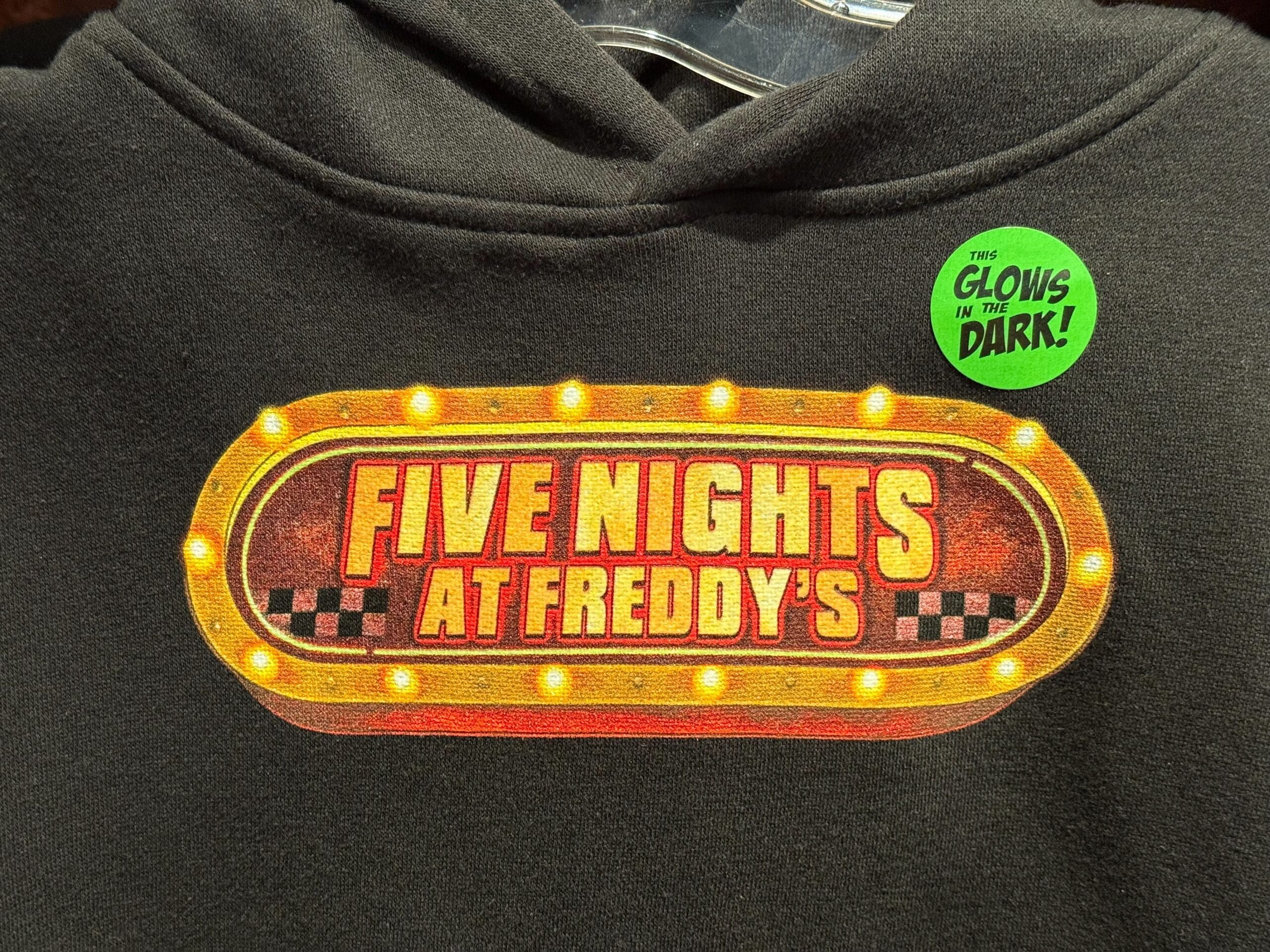 A "Five Nights at Freddy's" hoodie at Universal Studios with a green "This glows in the dark!" sticker.