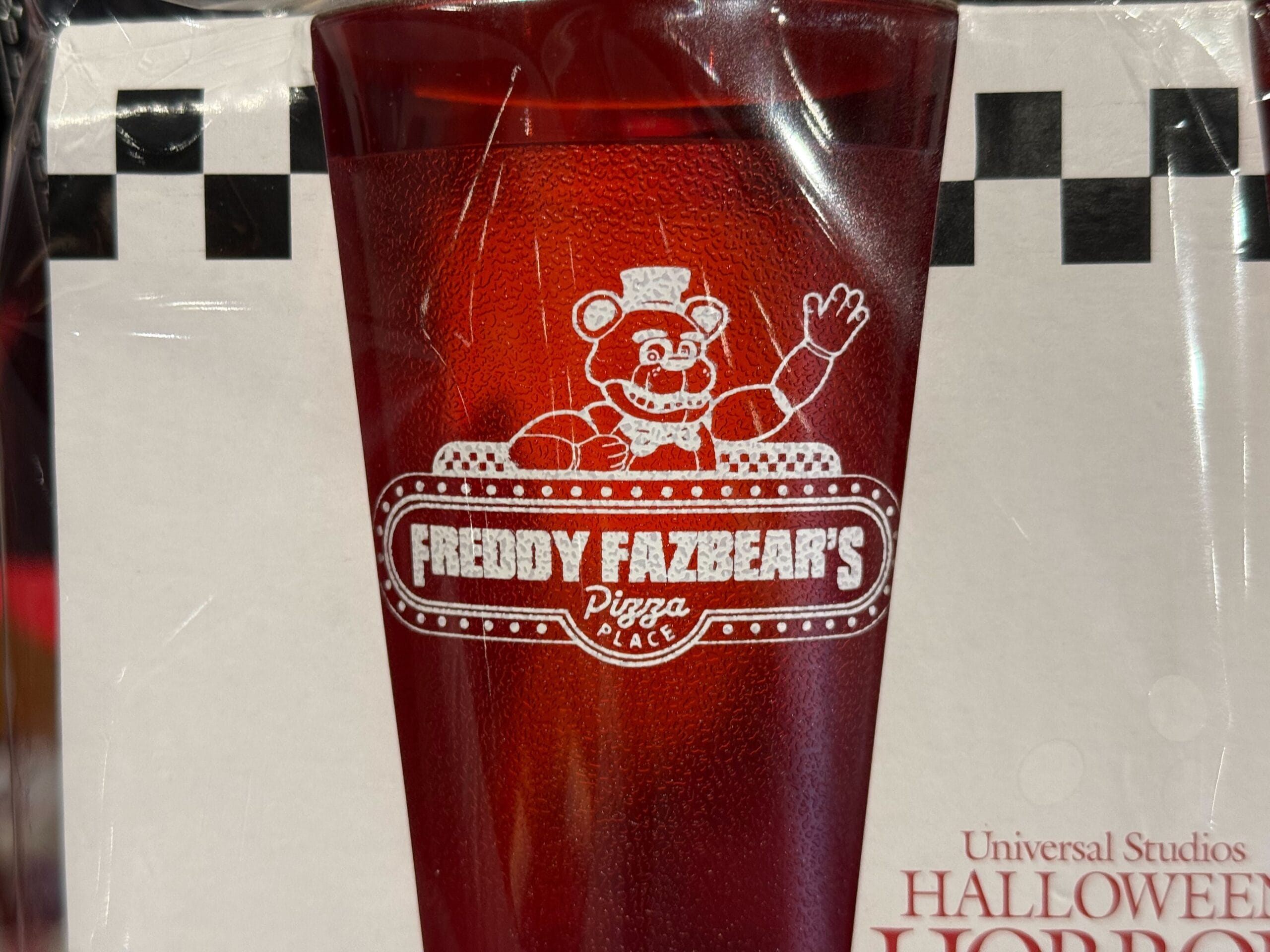 A red plastic Freddy Fazbear’s Pizza Place glass, 2025 Halloween Horror Nights merch at Universal.