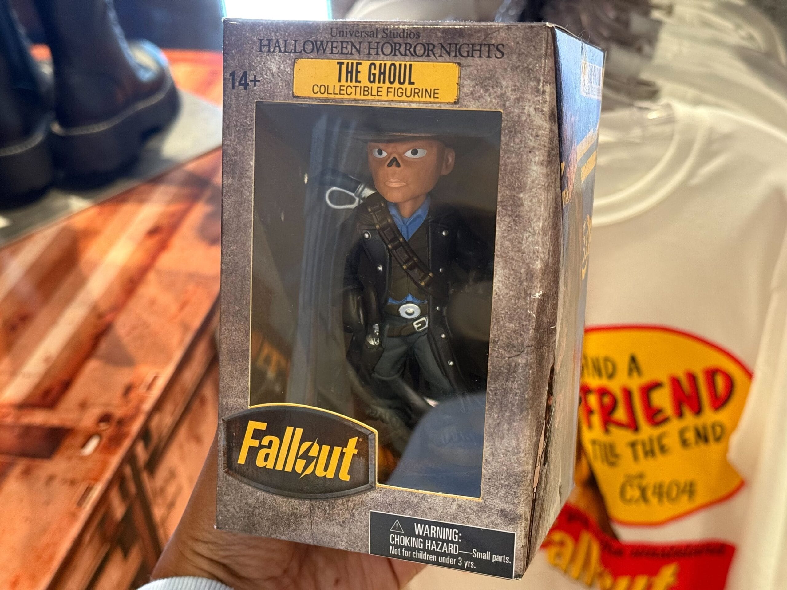 A hand holds a boxed Fallout "The Ghoul" collectible figurine, 2025 Universal Studios merch.