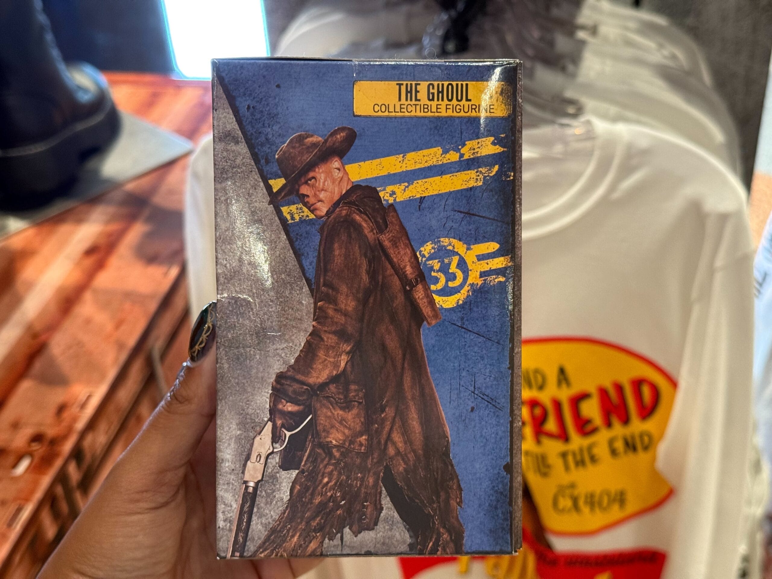 A hand holds Universal Studios "The Ghoul" cowboy figurine box from 2025 Halloween Horror Nights.
