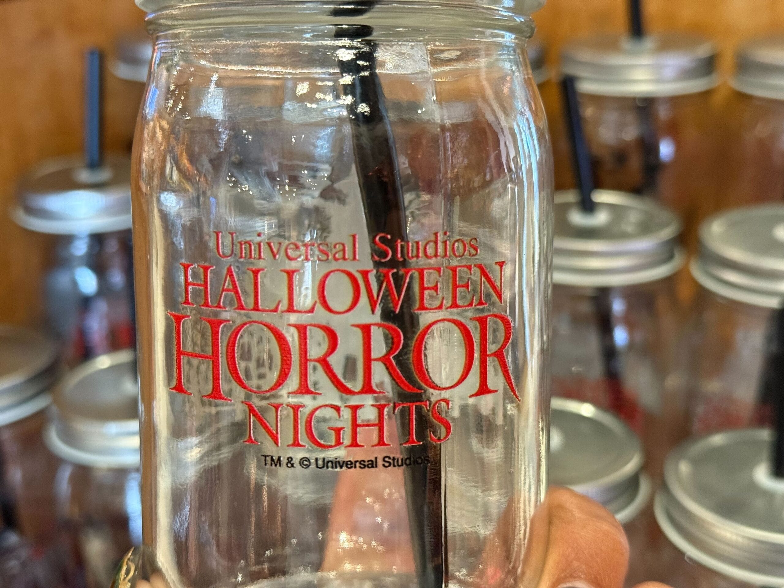 A glass mason jar with "Universal Studios Halloween Horror Nights" in red.