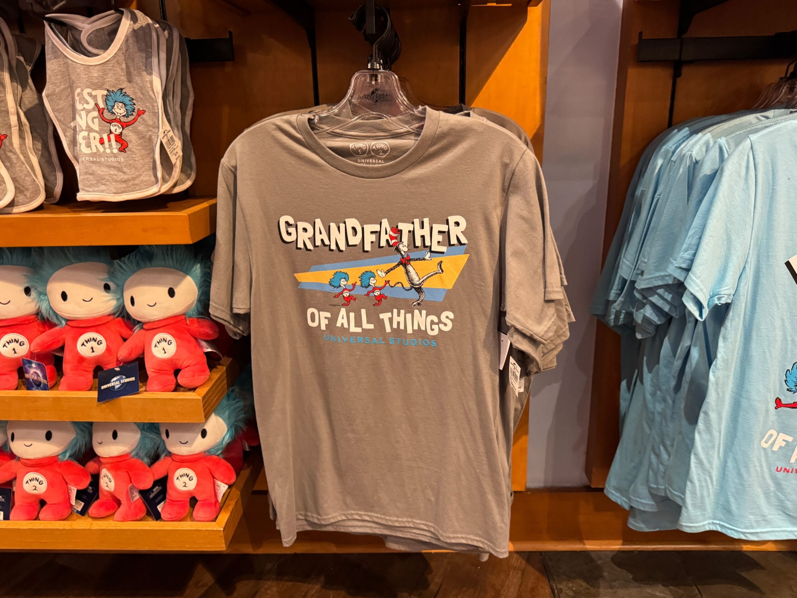 Gray t-shirt at Universal Studios says "Grandfather of All Things" with Thing 1 & Thing 2; no Disney castle like at any Disney parks.
