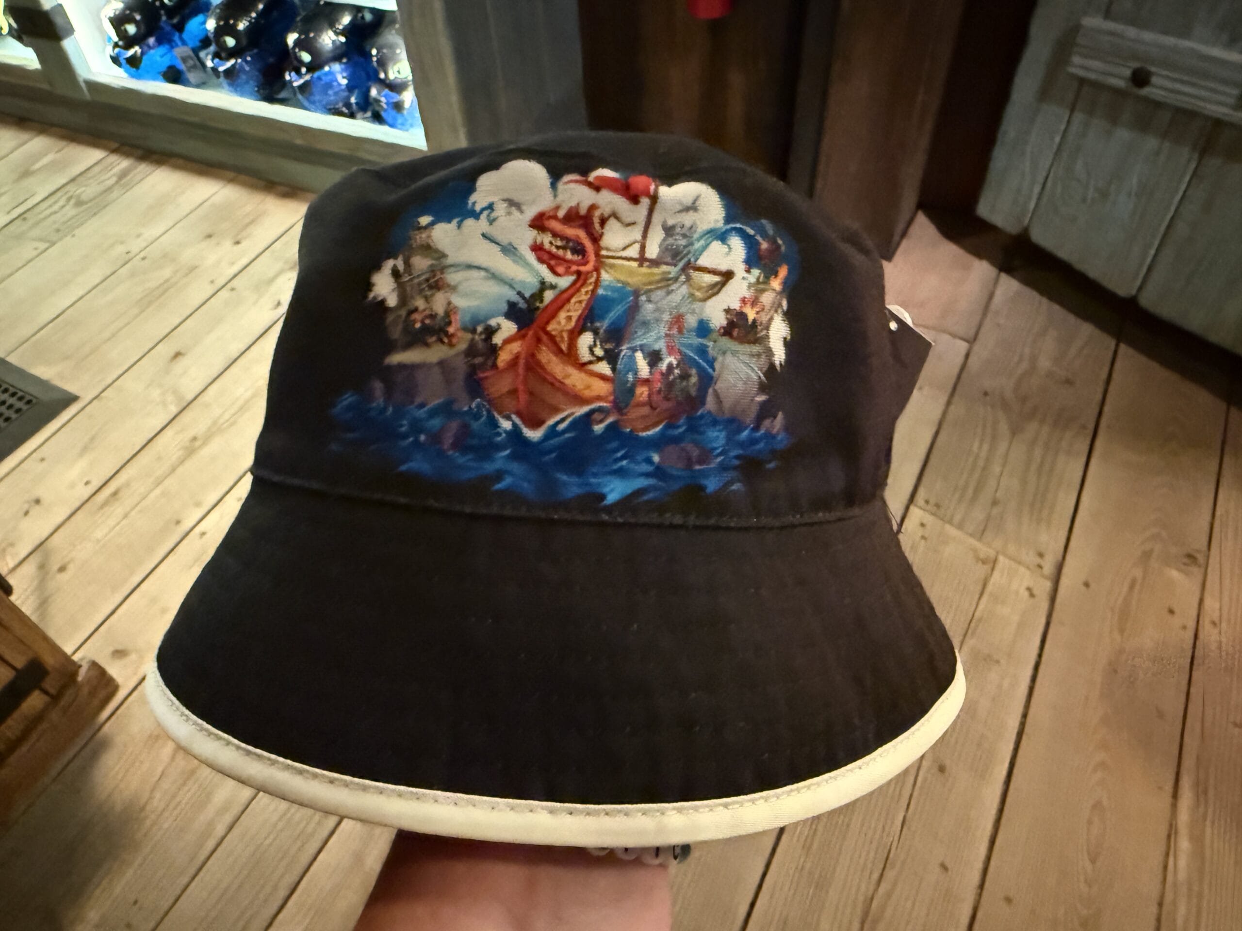 A black Spit Fyre bucket hat with a bold Viking ship and warriors—unique kiosk merch, not found at any Disney Park or by the castles.