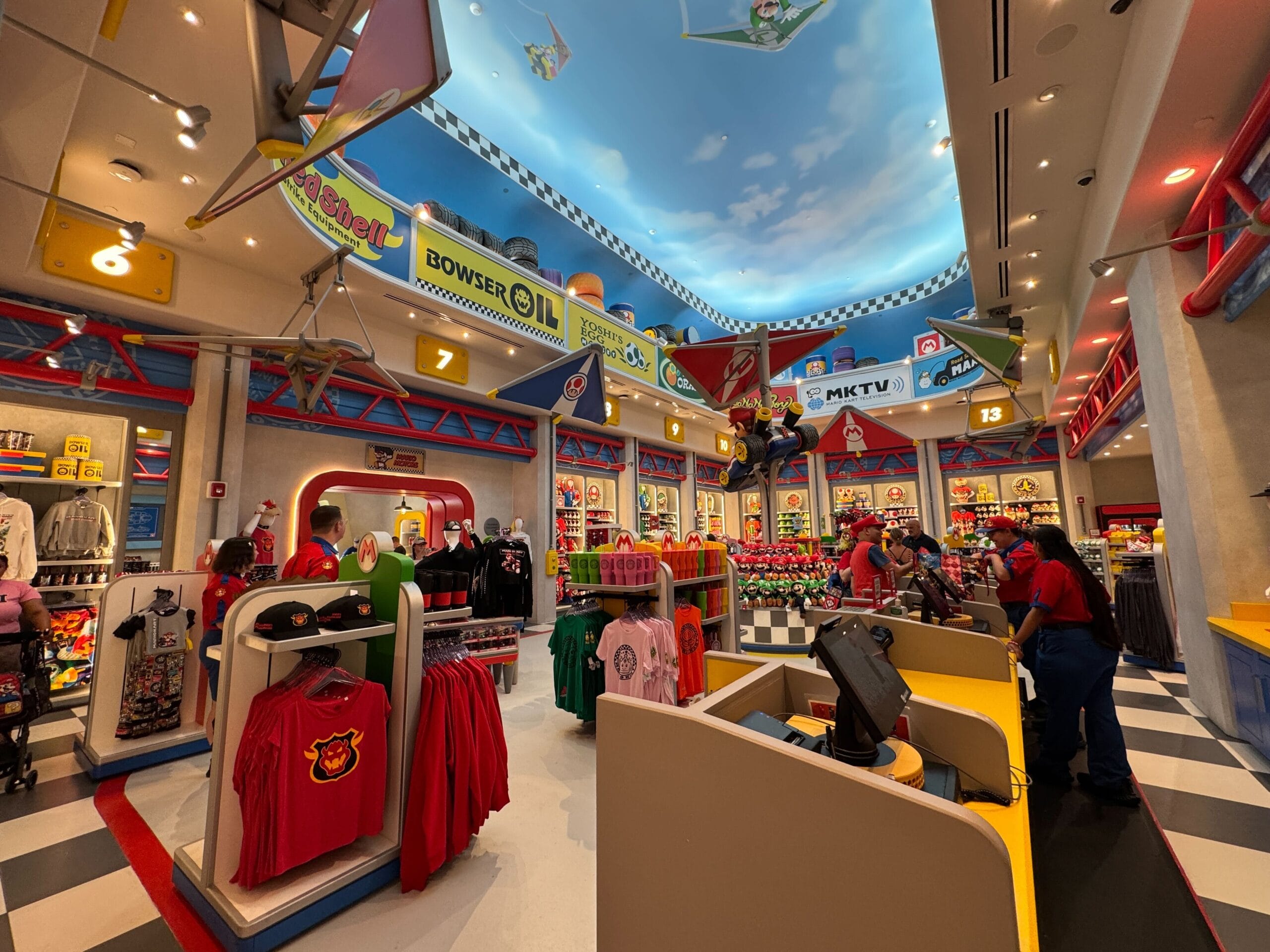 Colorful shop with Mario Motors decor, Nintendo-themed items, and vibrant lighting, reminiscent of Disney park stores, not castle-themed.