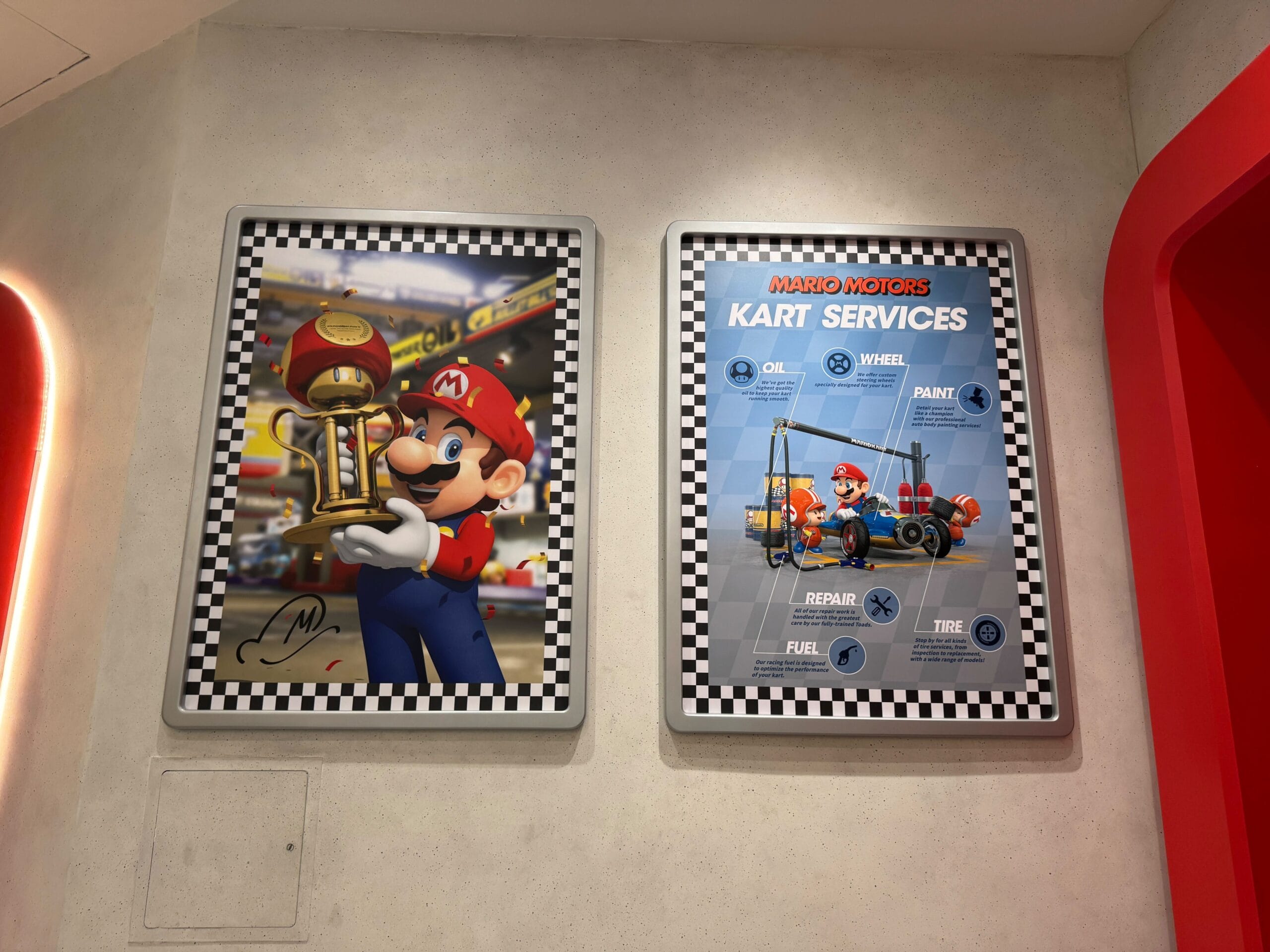 Two posters: Mario holding a trophy and a Mario Motors kart diagram—Super Nintendo World flair, no Cinderella Castle in sight!