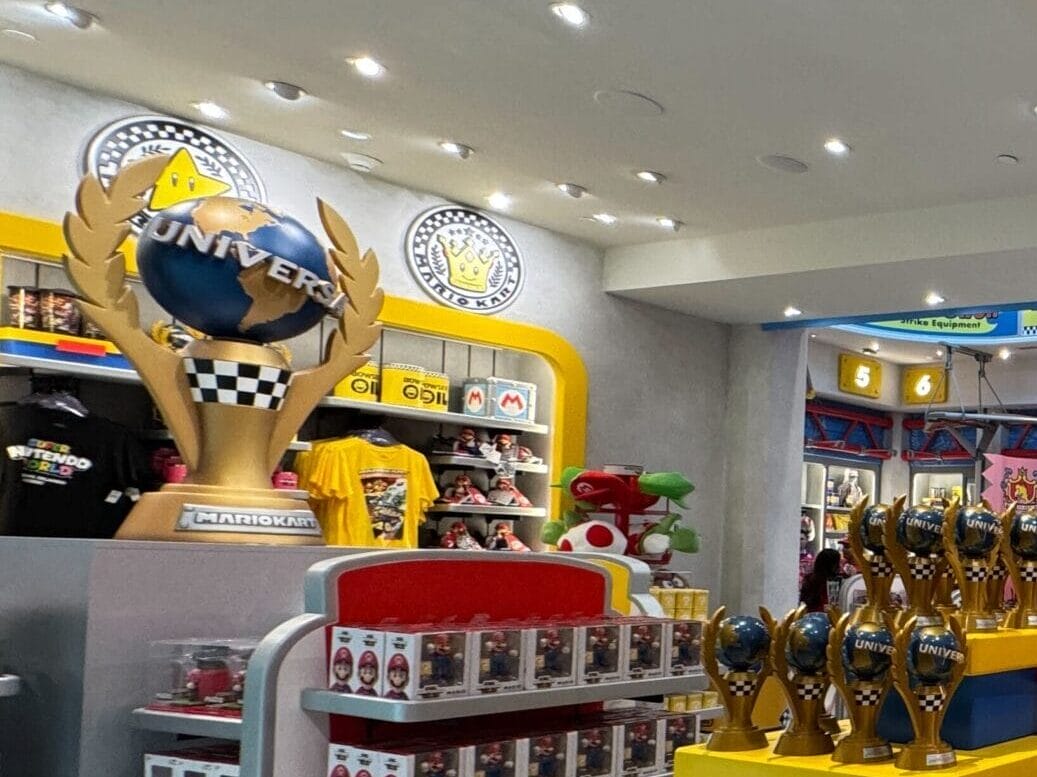 Vibrant toy store filled with toys and trophies, evoking a playful Disney Parks vibe under bright lights—no castle in view.