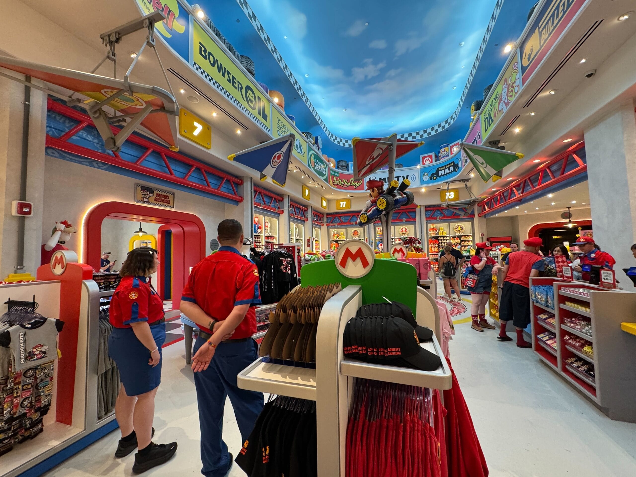 A vibrant Super Nintendo World shop with shoppers and Mario-themed decor—no iconic Disney castles like those at global Disney parks.