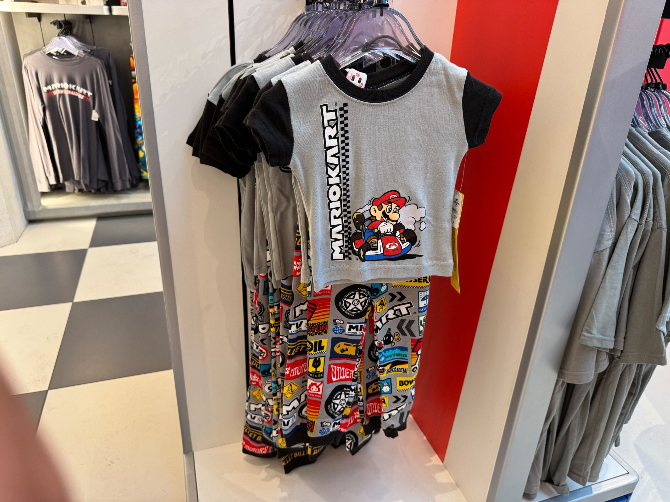 Children’s Mario Kart outfit with Mario graphic top and racing patches, distinct from Disney Parks attire; not a Disney castle style.