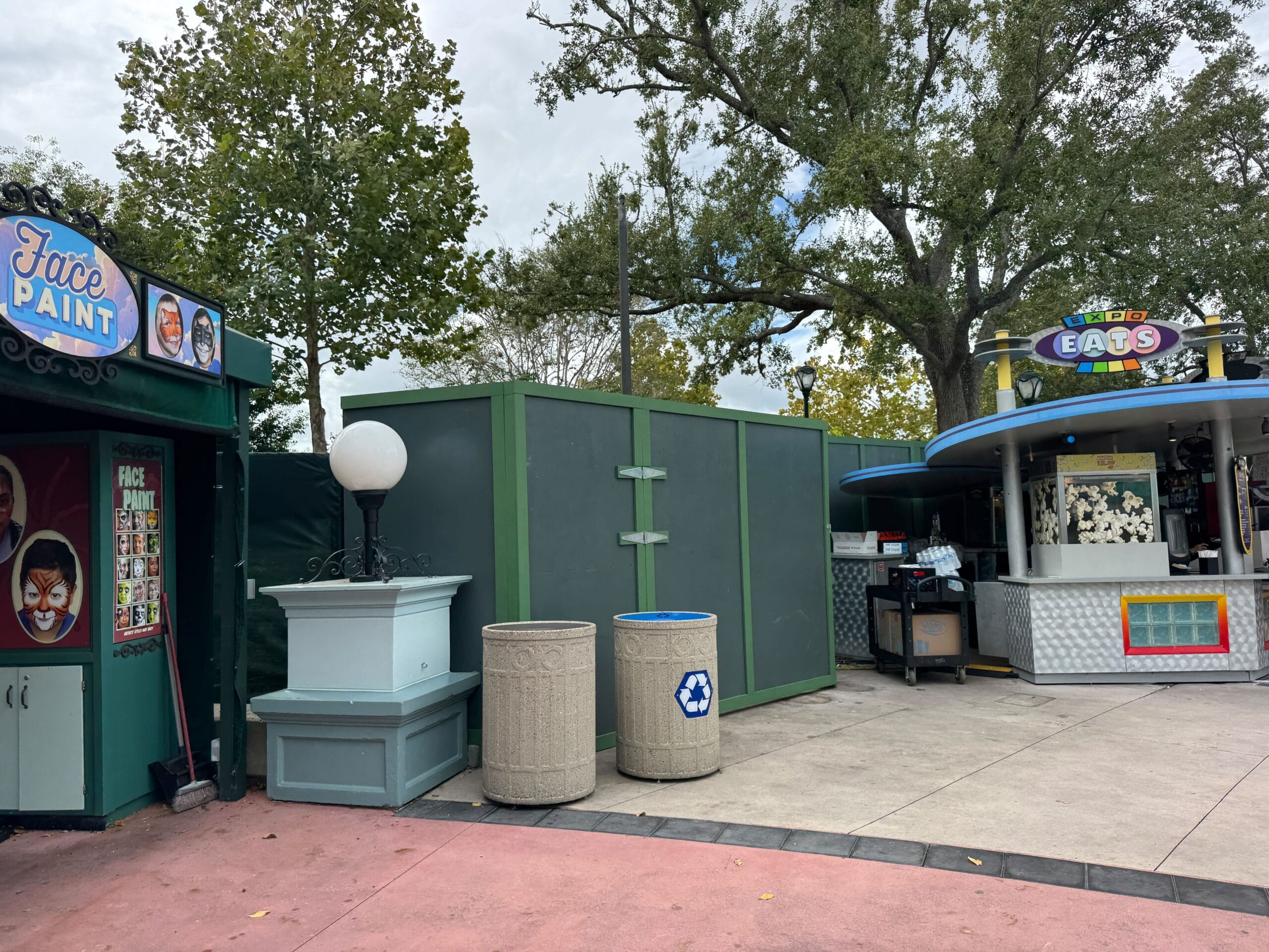 A building with a green wall, round light fixture, and construction walls, not resembling any Disney castle, at Universal Studios.
