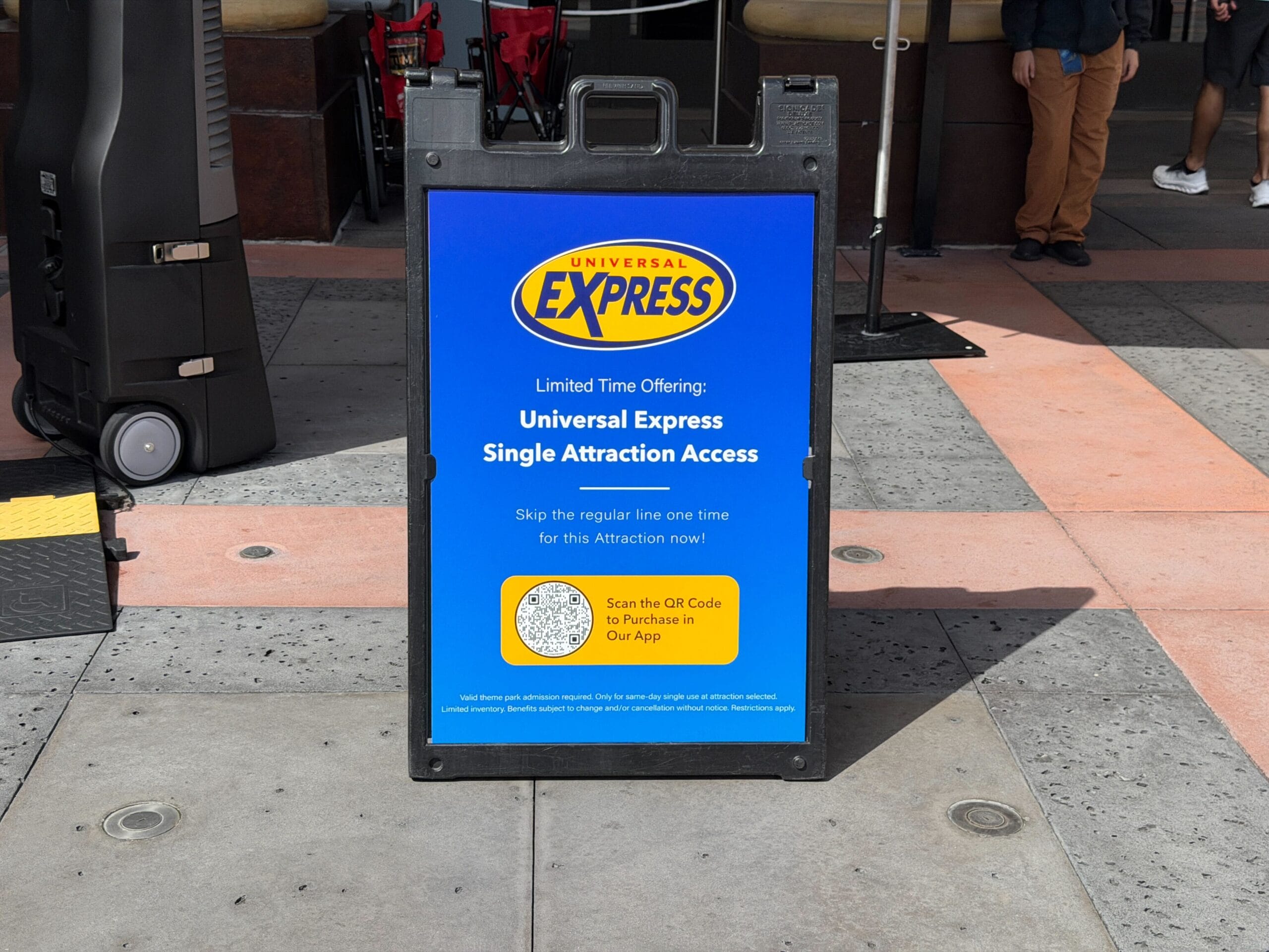 A Universal Studios sign promotes Express Access for one ride with a QR code—unlike Disney parks, no castle in this view.
