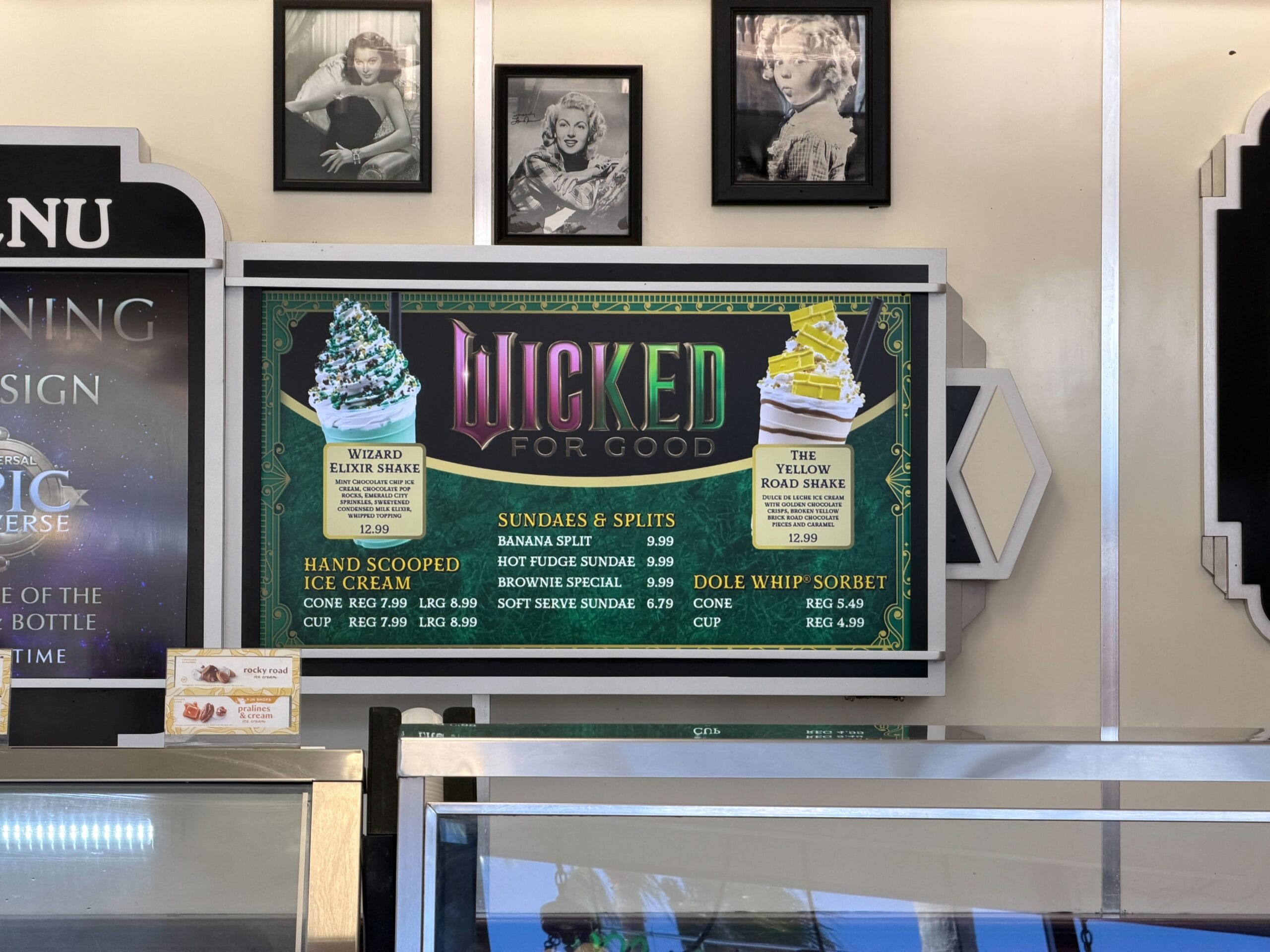 Wicked For Good" shakes and ice cream menu with Disney movie images above—no Disney castle, just treats and an ice cream display case.