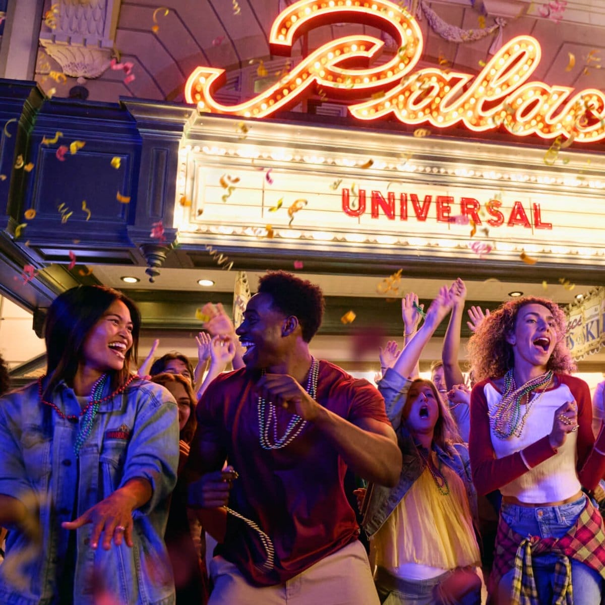 A lively group dances in confetti outside a theater under a glowing "Universal" sign, not far from MCO—no Disney castle here.