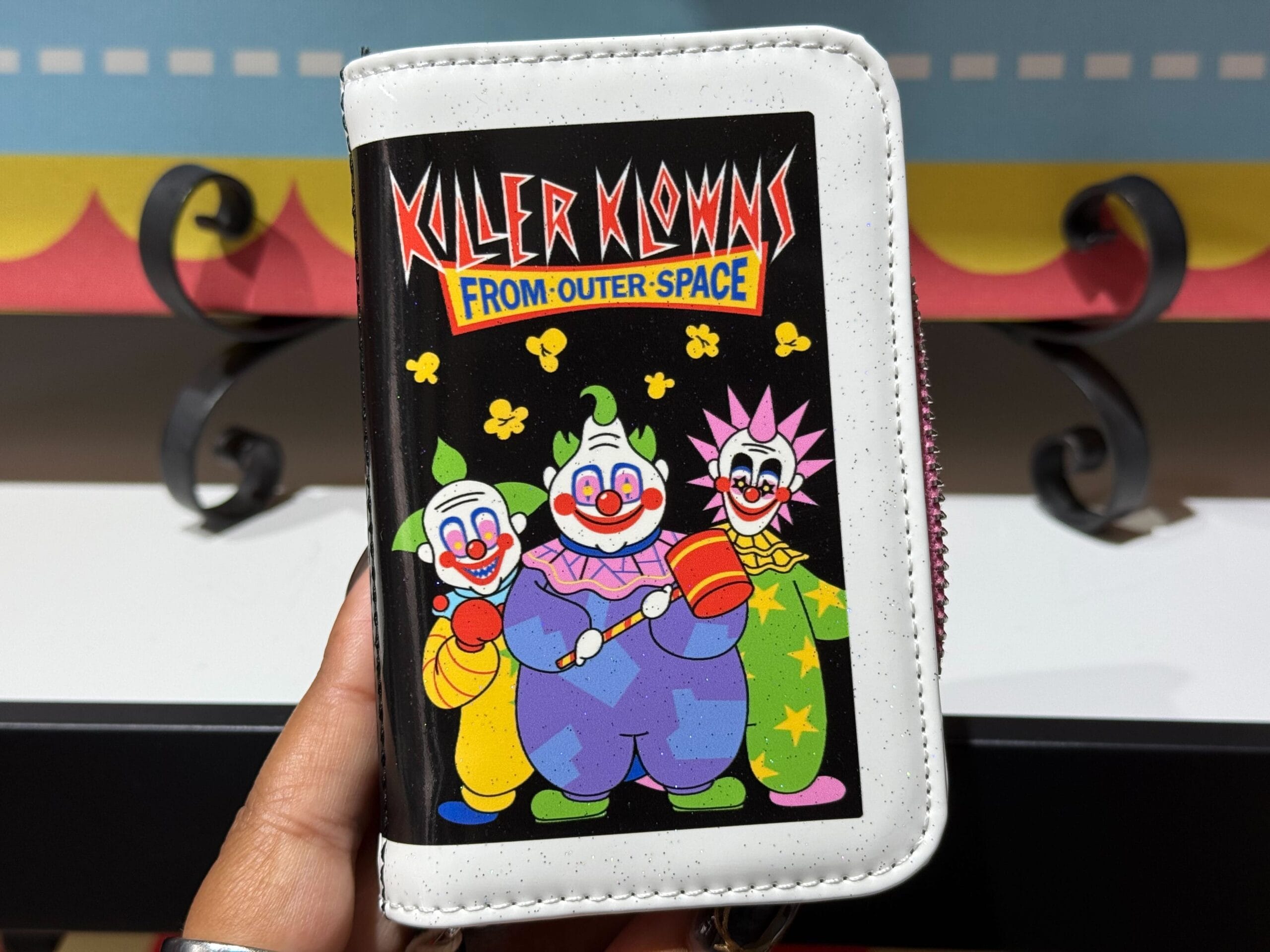 A wallet shows three vibrant clowns and "Killer Klowns from Outer Space."