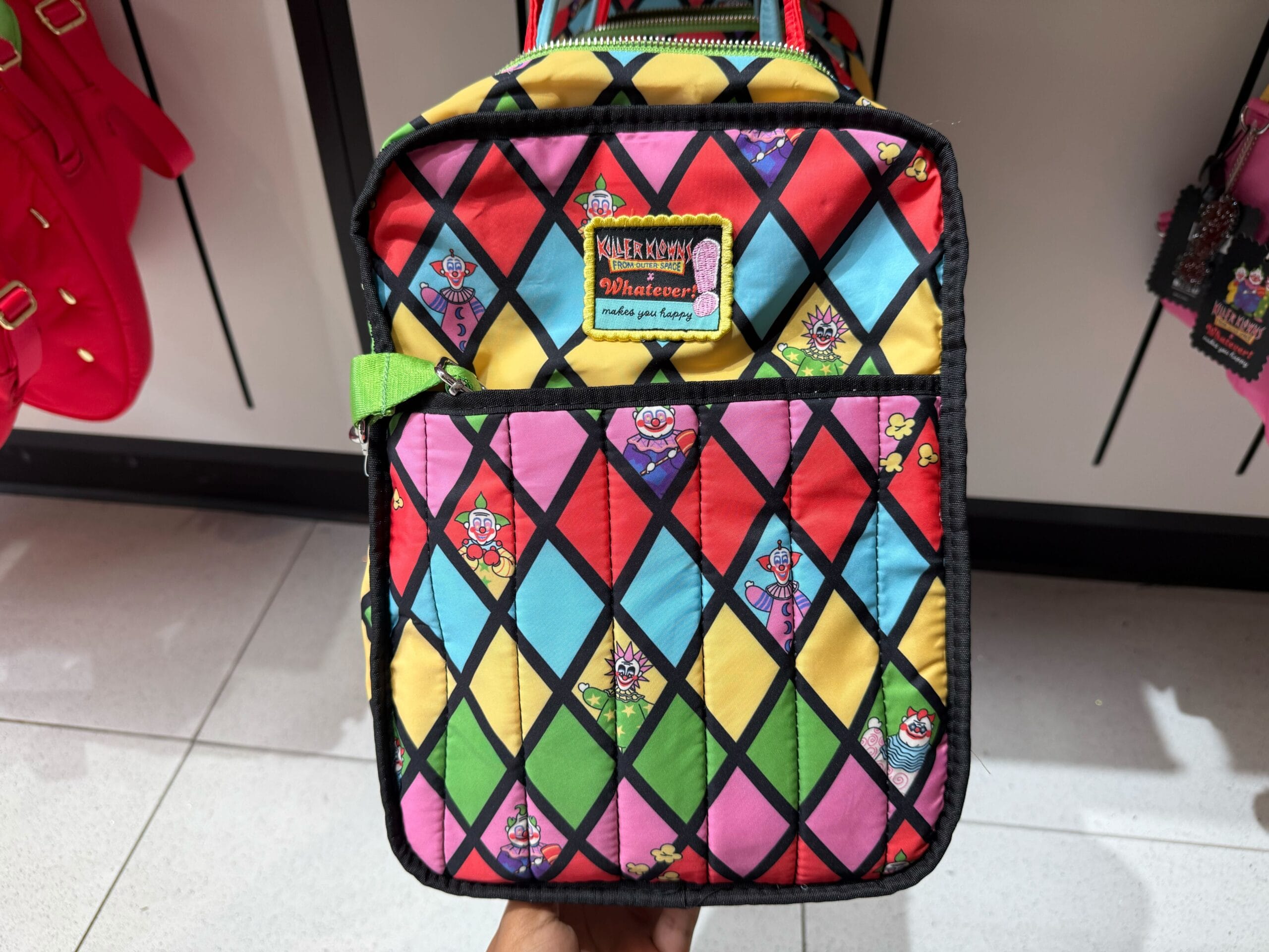 Colorful diamond-patterned bag with cartoon clowns, seen among 2025 merchandise.