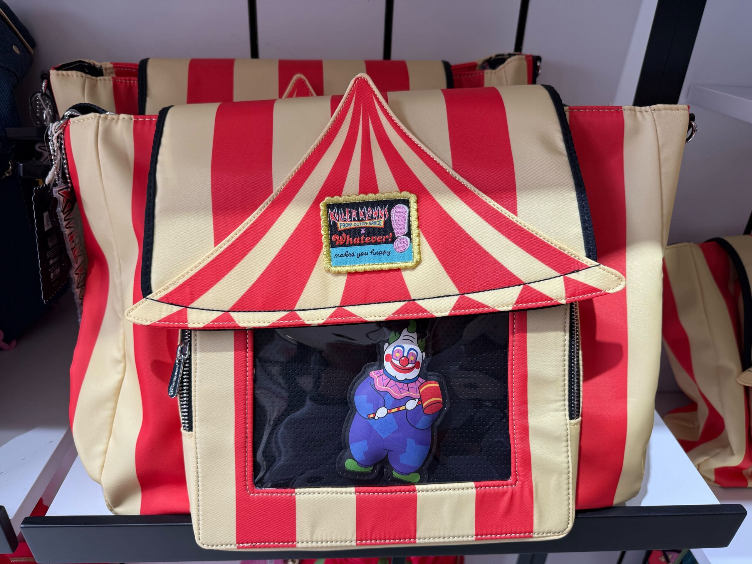 Red and beige striped circus tent bag with clown keychain, Killer Klowns from Outer Space merch.