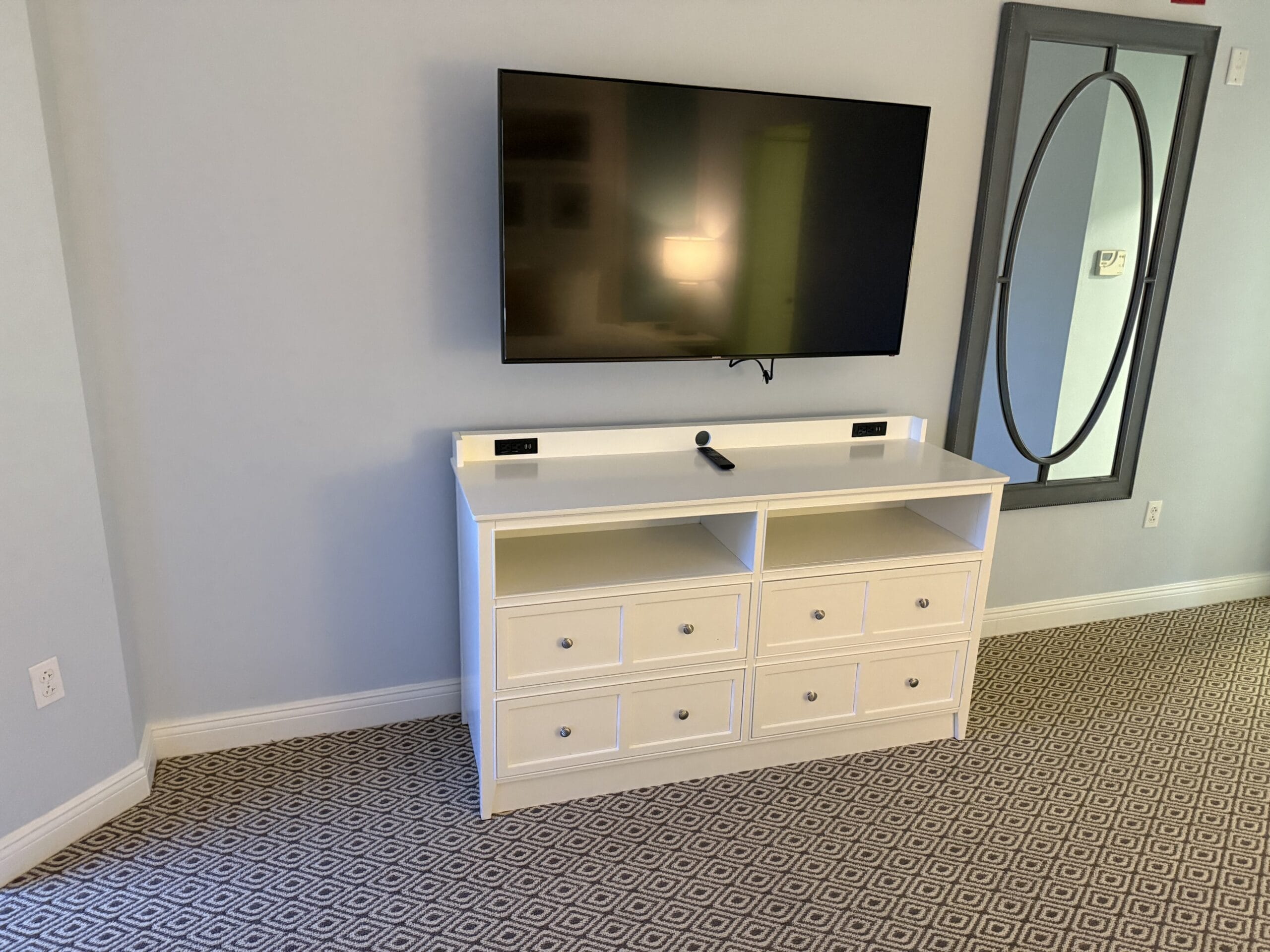 A flat-screen TV above a white dresser in a 3 Bedroom Cottage at Disney's Vero Beach Resort, no castle like those in Disney parks.