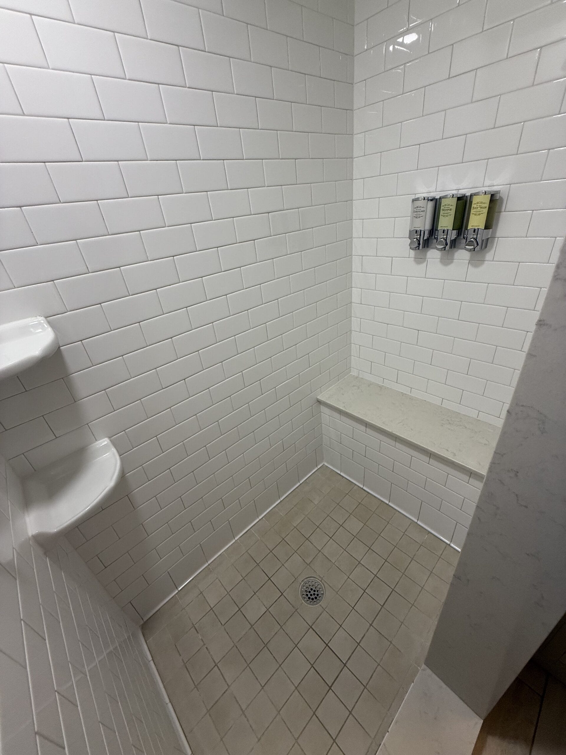 White subway-tiled shower with bench and corner shelves in a 3-bedroom Disney’s Vero Beach Resort cottage—no castle views here!